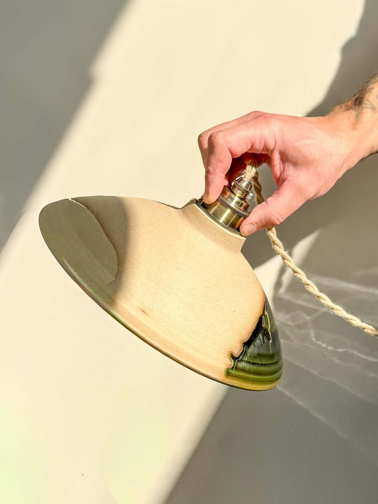 Ceramic Lamp Shade – Mori #02 Custom Order with forest green glossy glaze and raw tactile exterior, held in natural light.