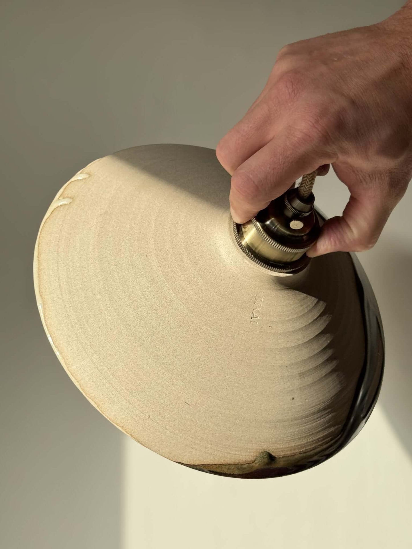 Hand holding Ceramic Lamp Shade – Inyo #02, showcasing the handmade ceramic texture with natural glaze drips.