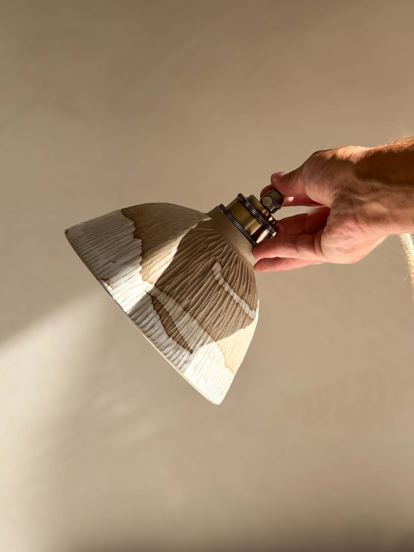 Hand holding Ceramic Lamp Shade – Yuki Series, showcasing handmade ceramic design with white glaze and carved ridges for a warm, organic feel.