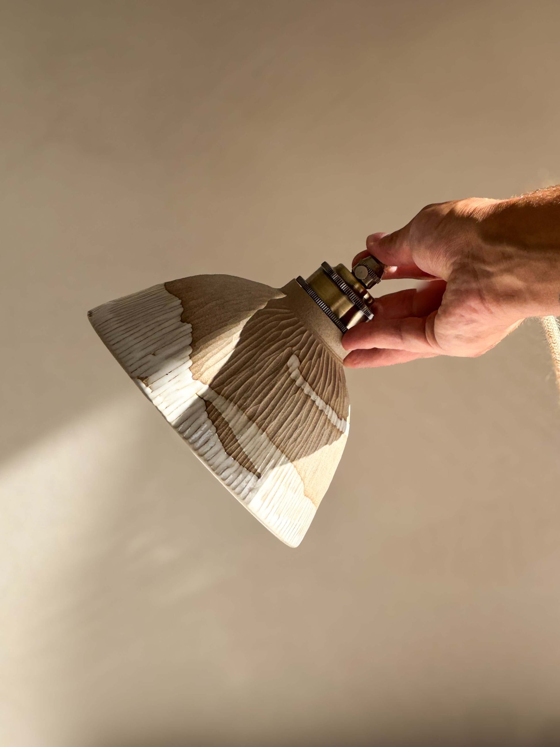 Hand holding Ceramic Lamp Shade – Yuki Series, showcasing handmade ceramic design with white glaze and carved ridges for a warm, organic feel.