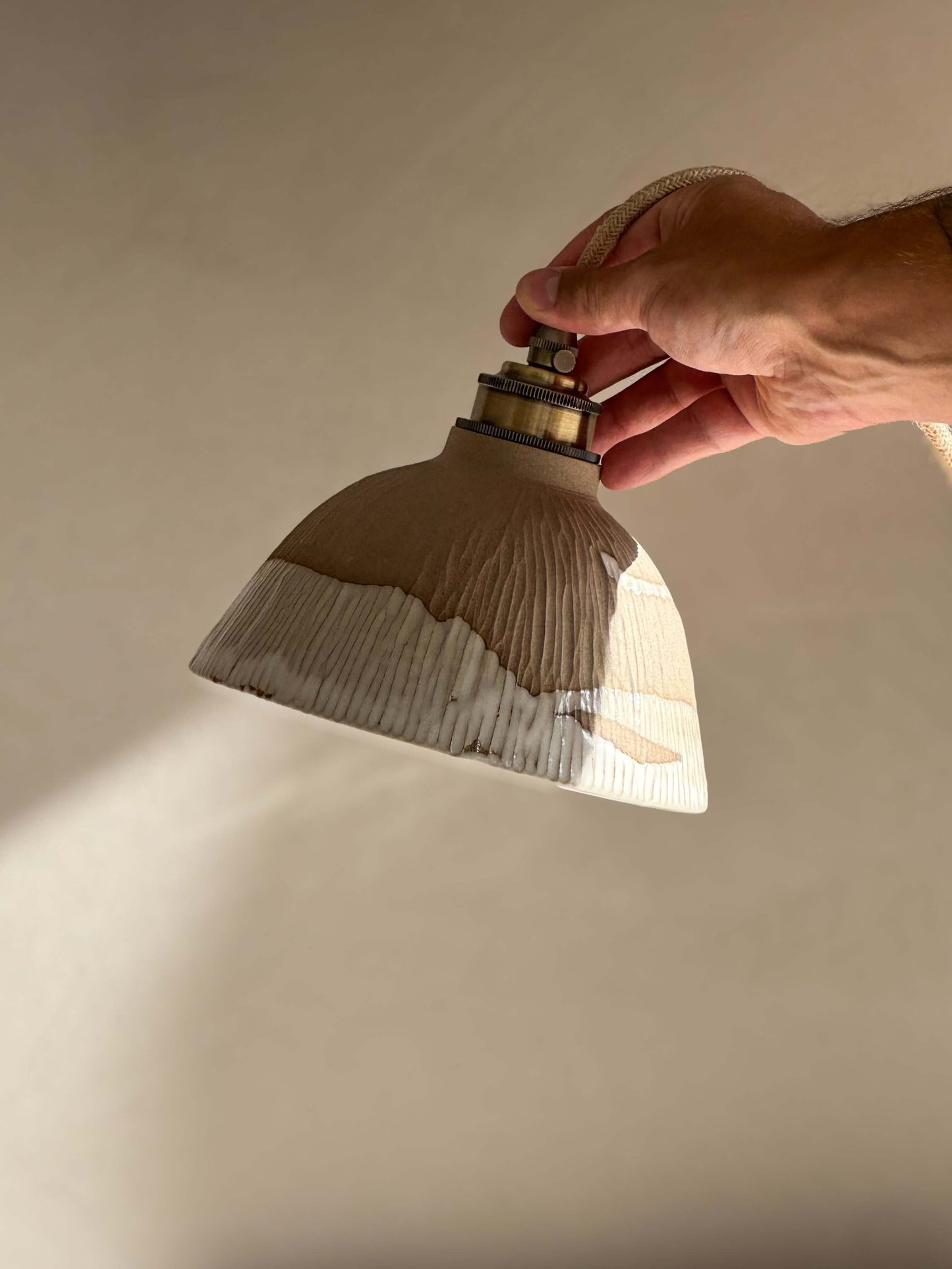 Hand holding Ceramic Lamp Shade – Yuki Series with white glaze over carved ridges, showcasing handmade ceramic design.