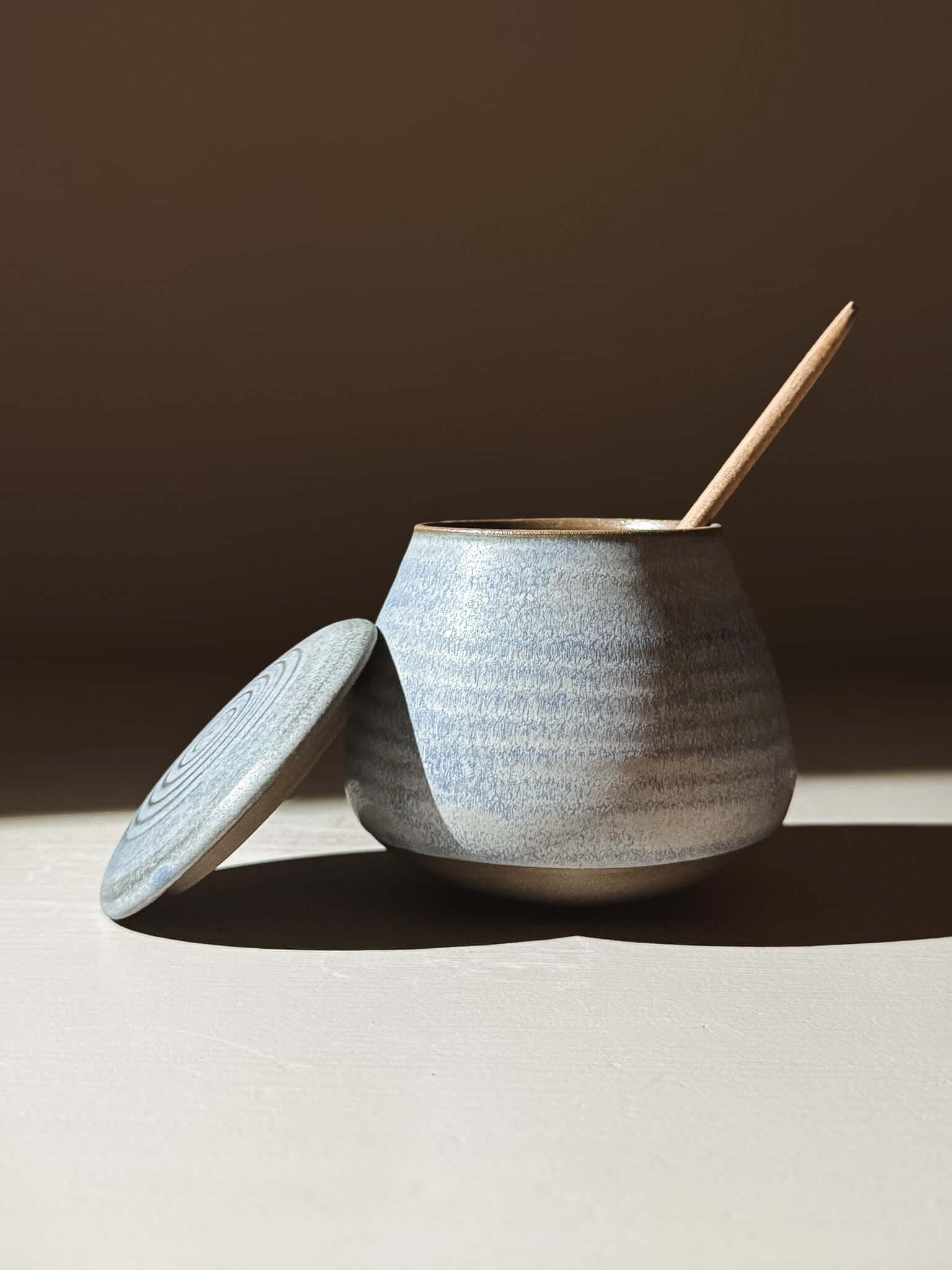 Handmade ceramic Lidded Jar - Mizu #01 with lid and wooden spoon, showcasing artistic pottery craftsmanship.