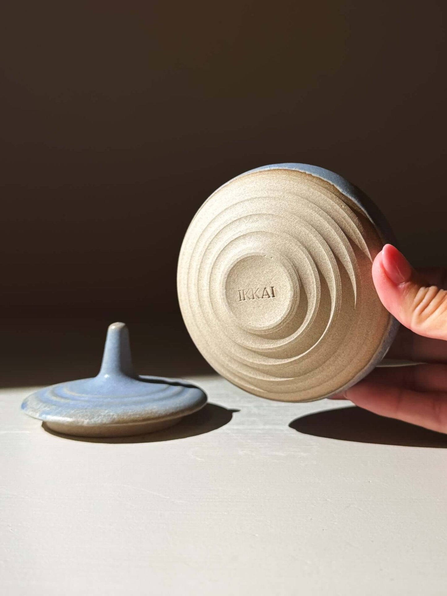 Hand holding Lidded Jar - Mizu #02, a handmade ceramic pottery piece highlighting its lid texture.
