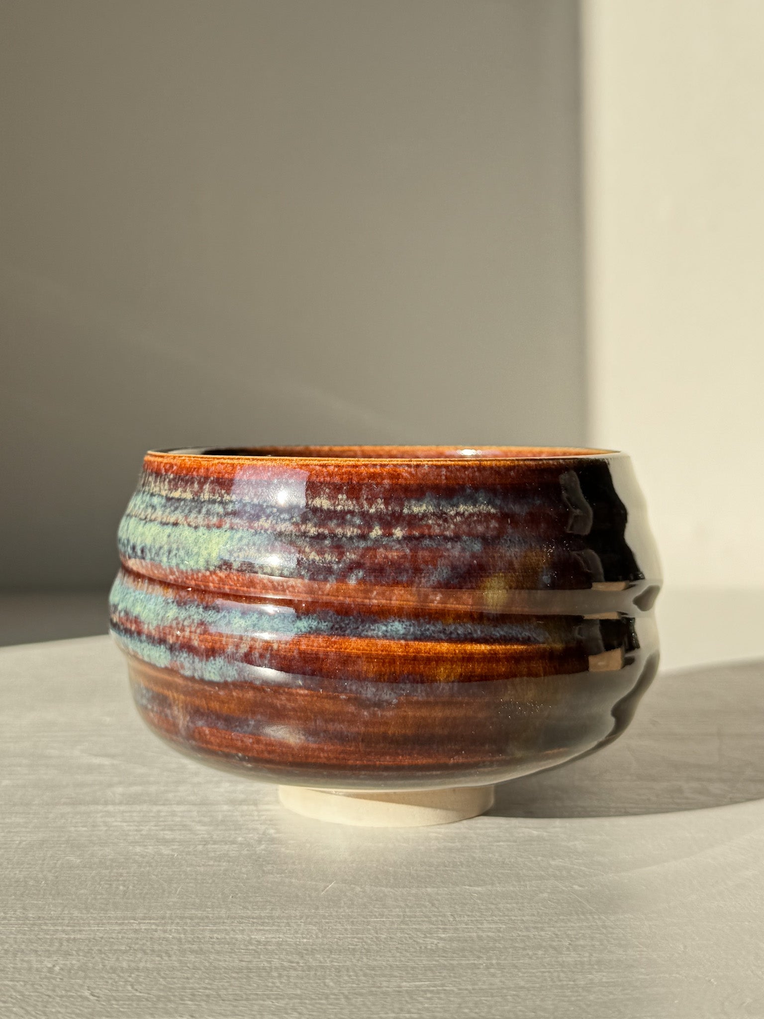 Matcha Bowl - Glossy Blue #03 with earthy tones and flowing blue glaze on a textured, curved design.