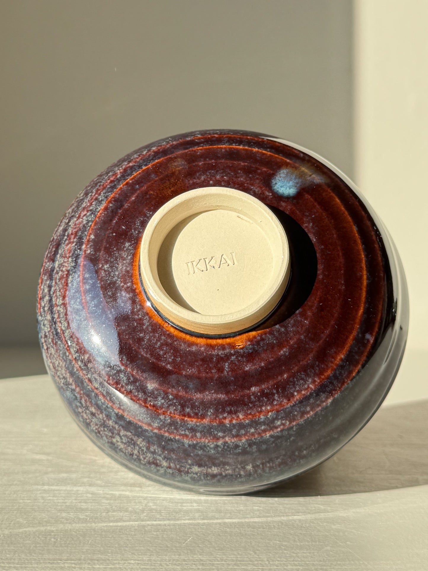 Underside of Matcha Bowl - Glossy Blue #01 showing unique textures and earthy tones with a raised foot design.