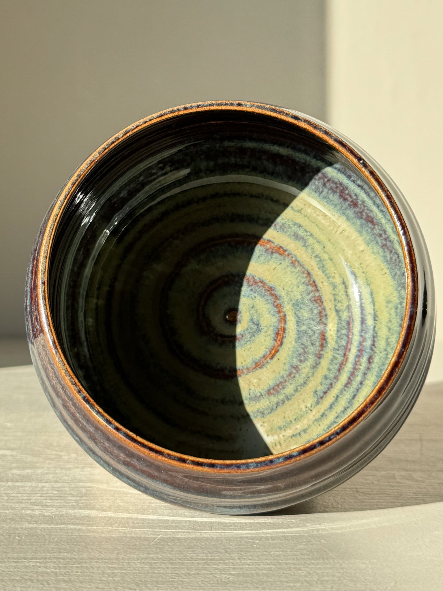 Matcha Bowl - Glossy Blue #01 showcasing unique earthy tones and flowing blues with a smooth, curved design on a light surface.