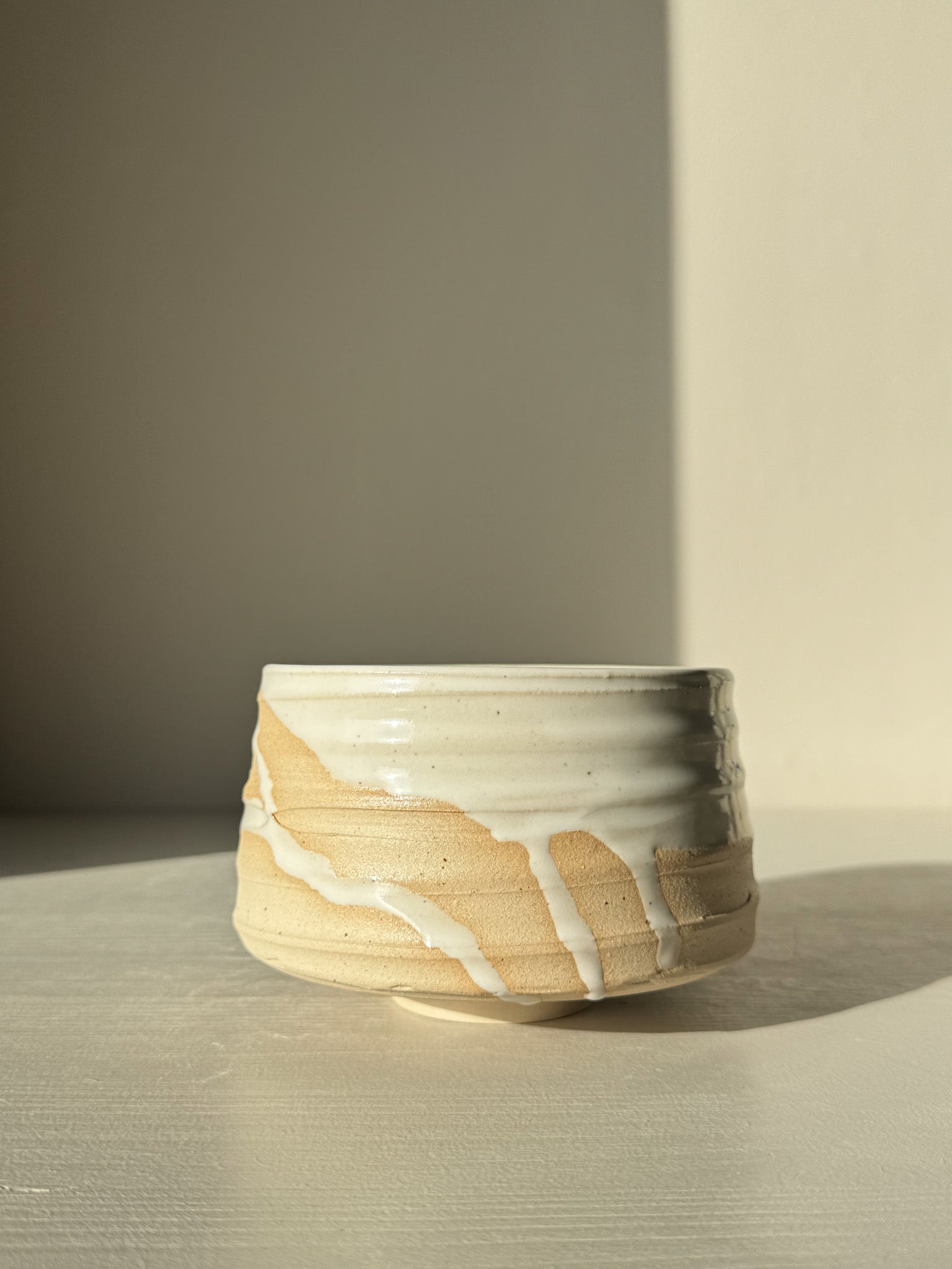 Matcha Bowl – Glossy White #03 made with speckled stoneware clay, showcasing a bold silhouette and glossy white glaze with natural drips.