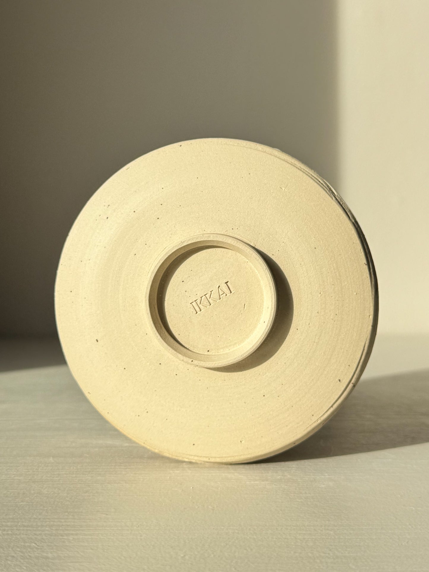 Underside view of Matcha Bowl – Glossy White #05 showing unglazed speckled stoneware clay base.