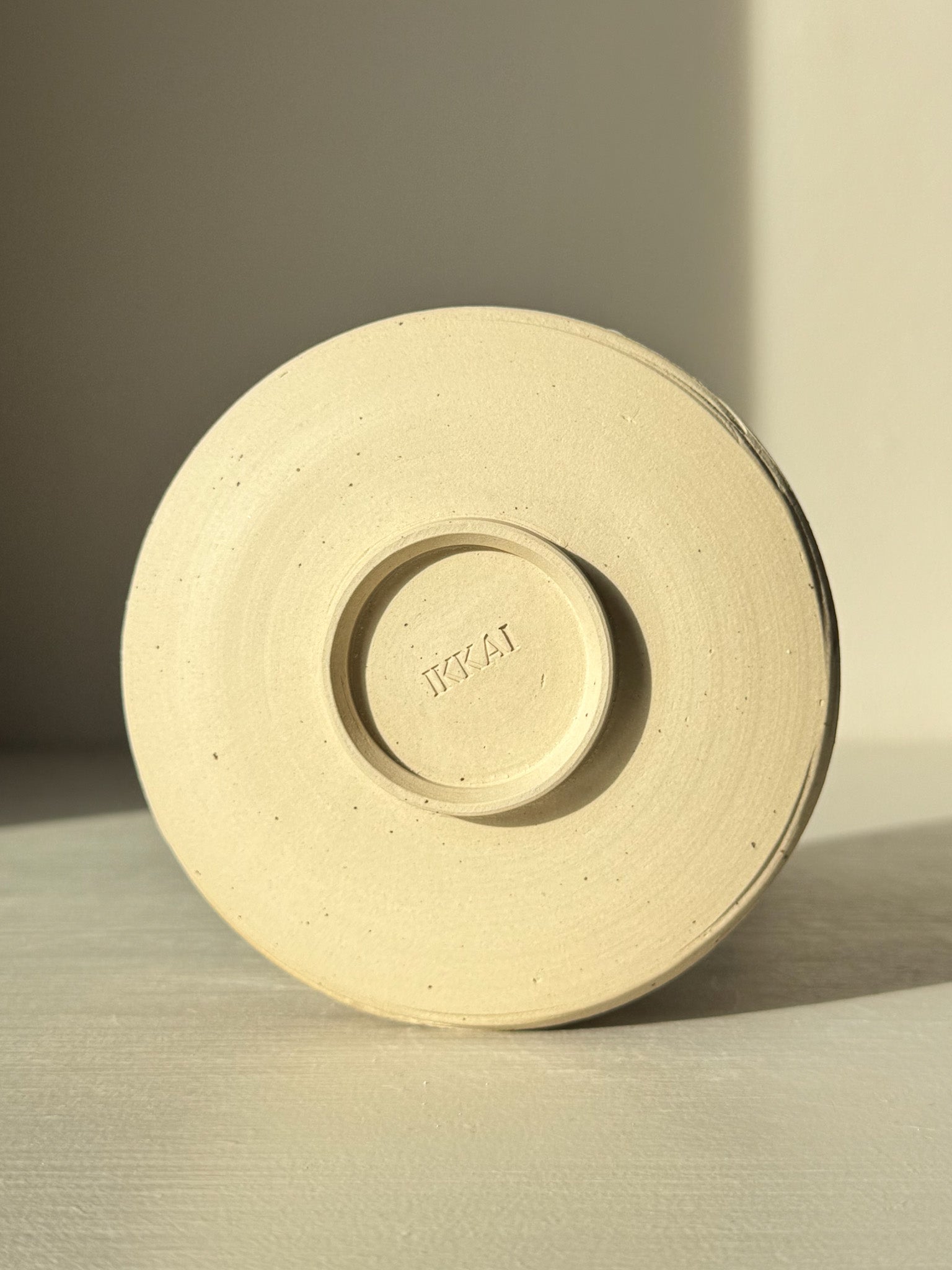 Underside view of Matcha Bowl – Glossy White #05 showing unglazed speckled stoneware clay base.