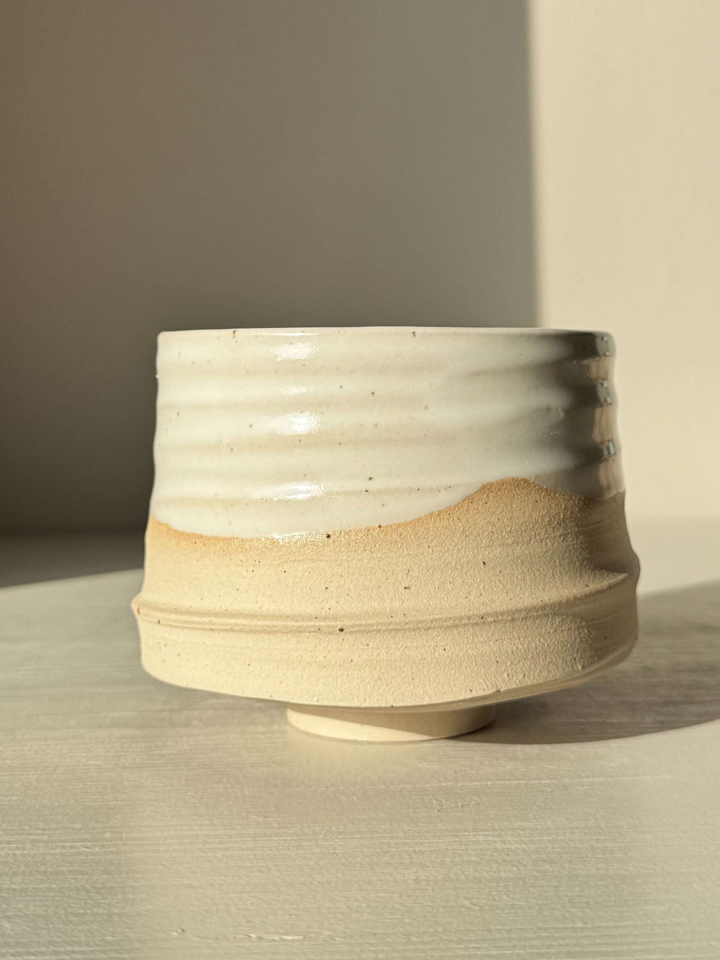 Handmade ceramic Matcha Bowl – Half Glossy White Glaze #02 with speckled stoneware, showcasing a glossy finish and tactile surface.