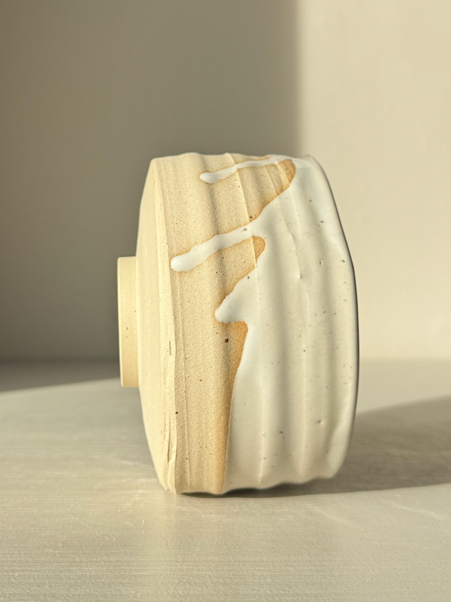 Side view of Matcha Bowl – Glossy White #05 with speckled stoneware clay and glossy white glaze showing natural drip pattern.