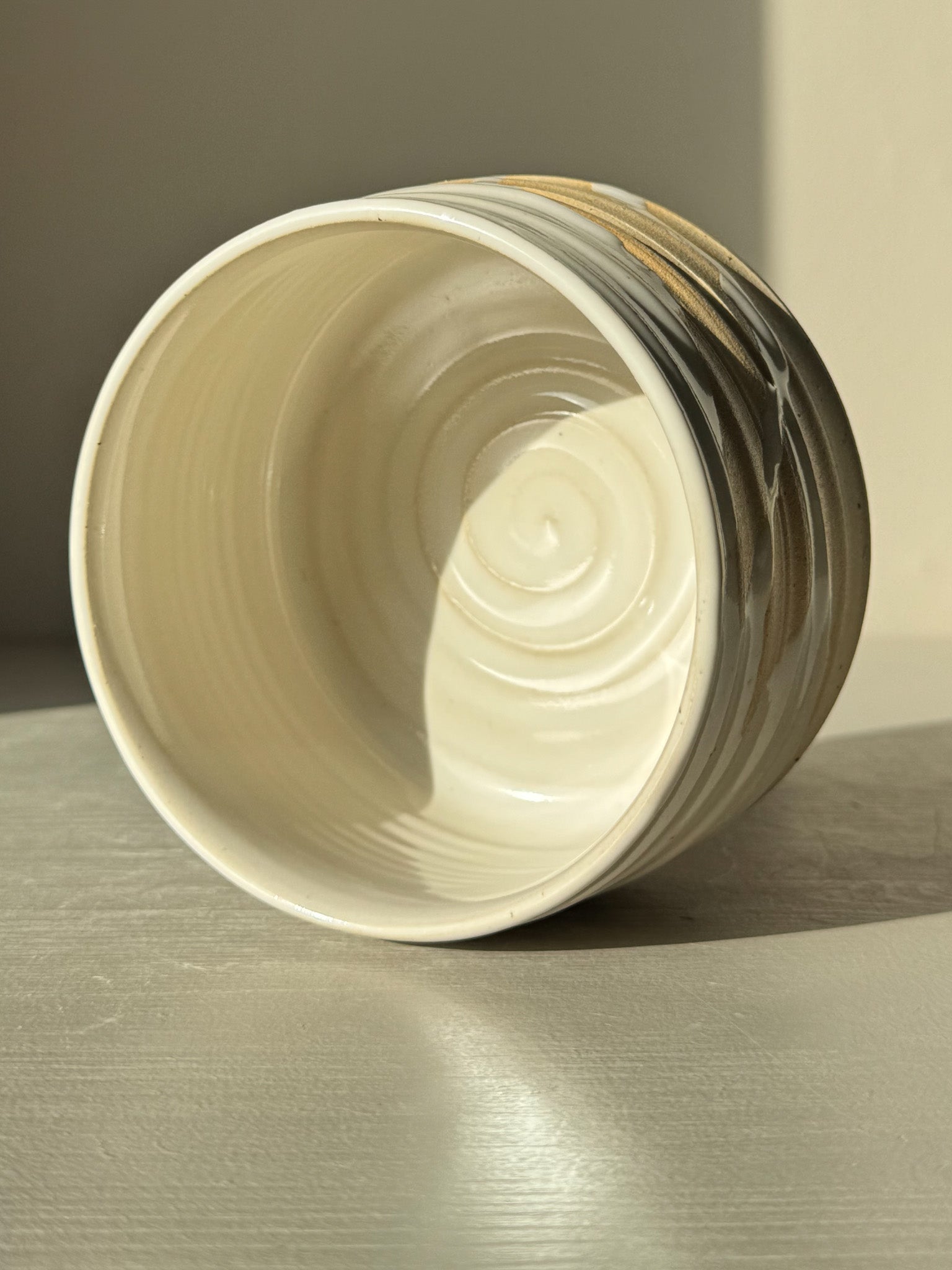 Matcha Bowl – Glossy White #03 with speckled stoneware clay and flowing glossy glaze on a textured surface.