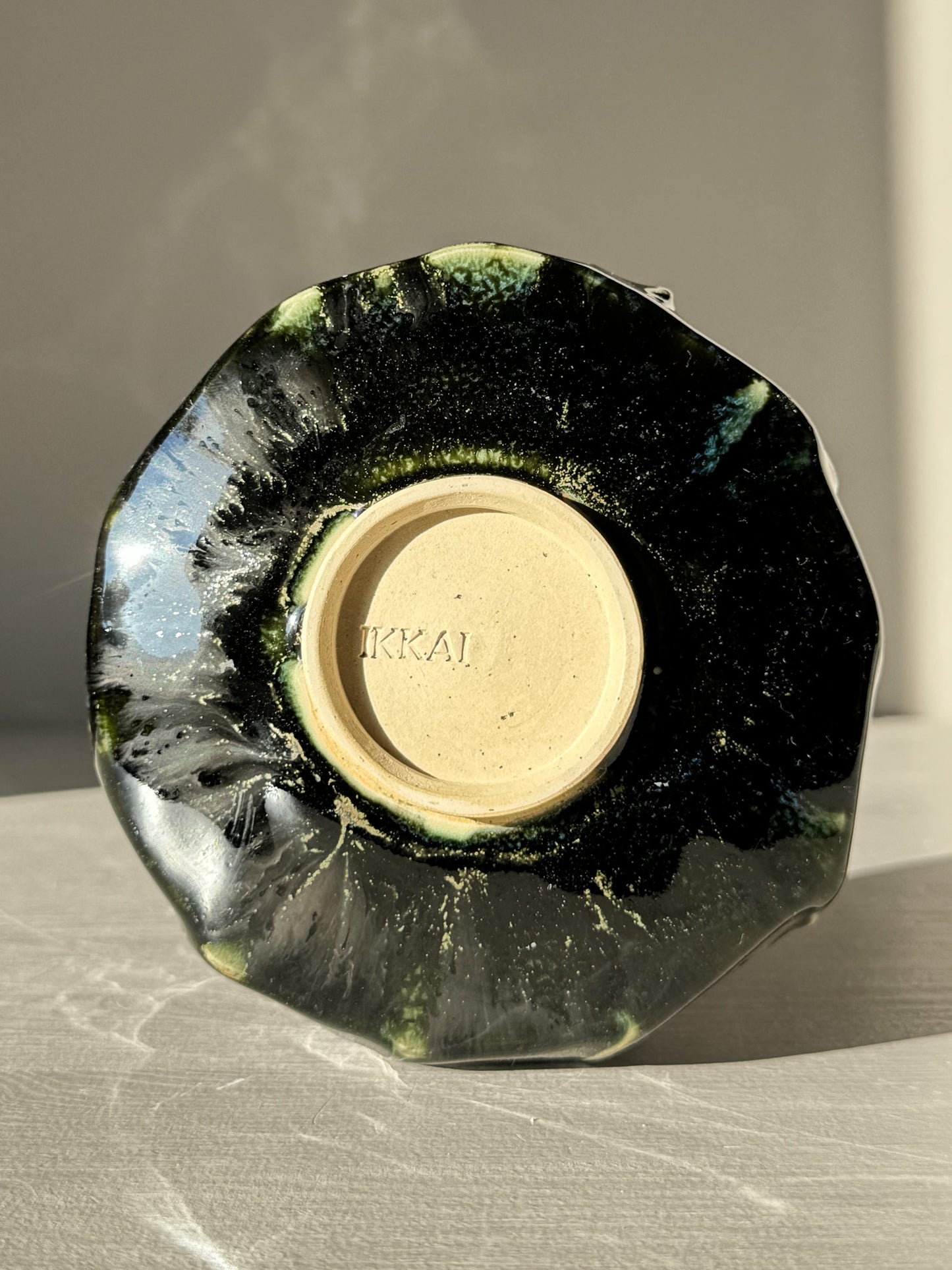 Bottom view of Textured Matcha Bowl - Hinoki #14 with green glaze and footprint mark, showcasing unique textured finish.