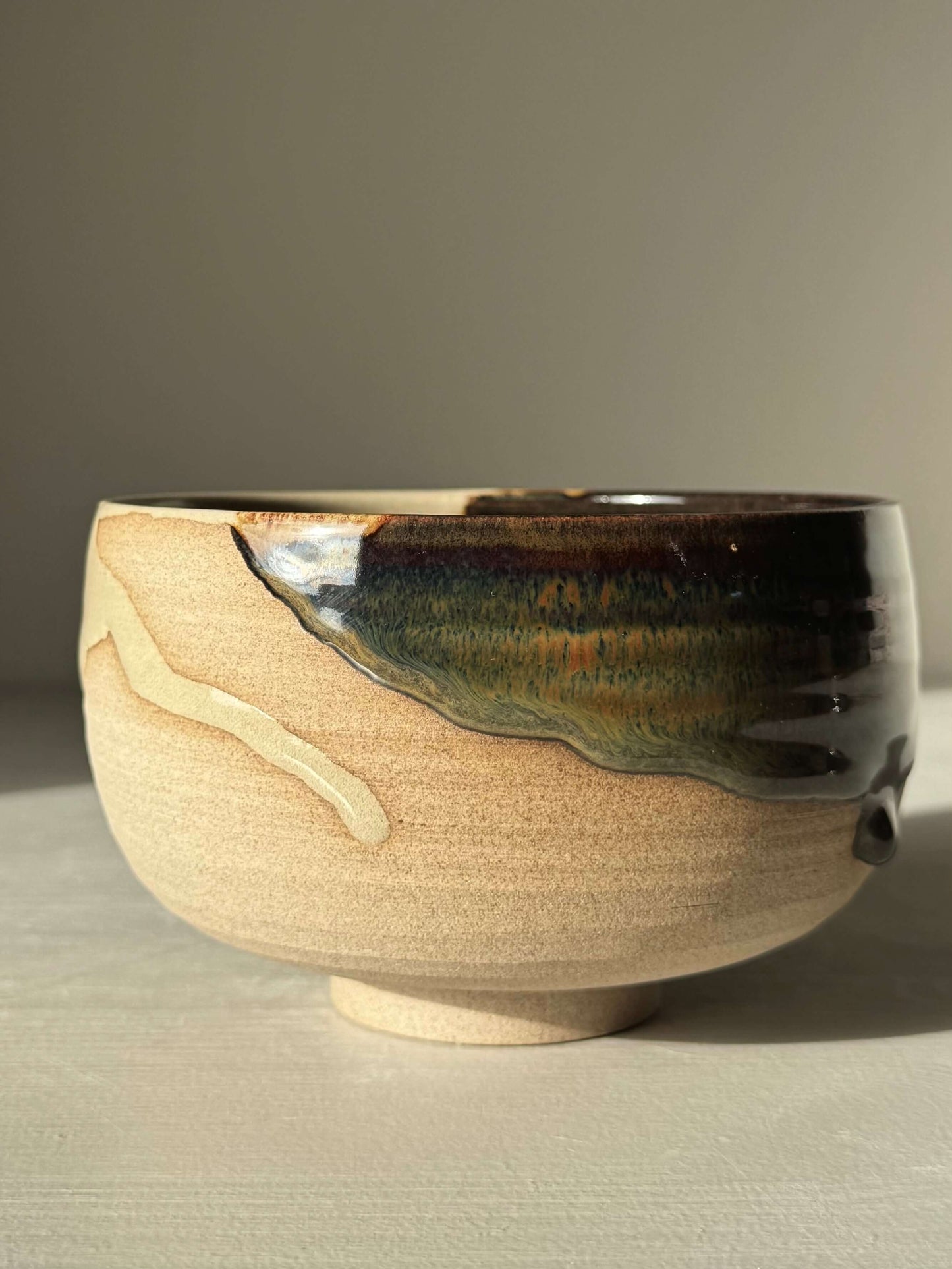 Handmade ceramic Matcha Bowl – Inyo #01 with tenmoku and clear glaze on stoneware, showcasing unique rounded design.