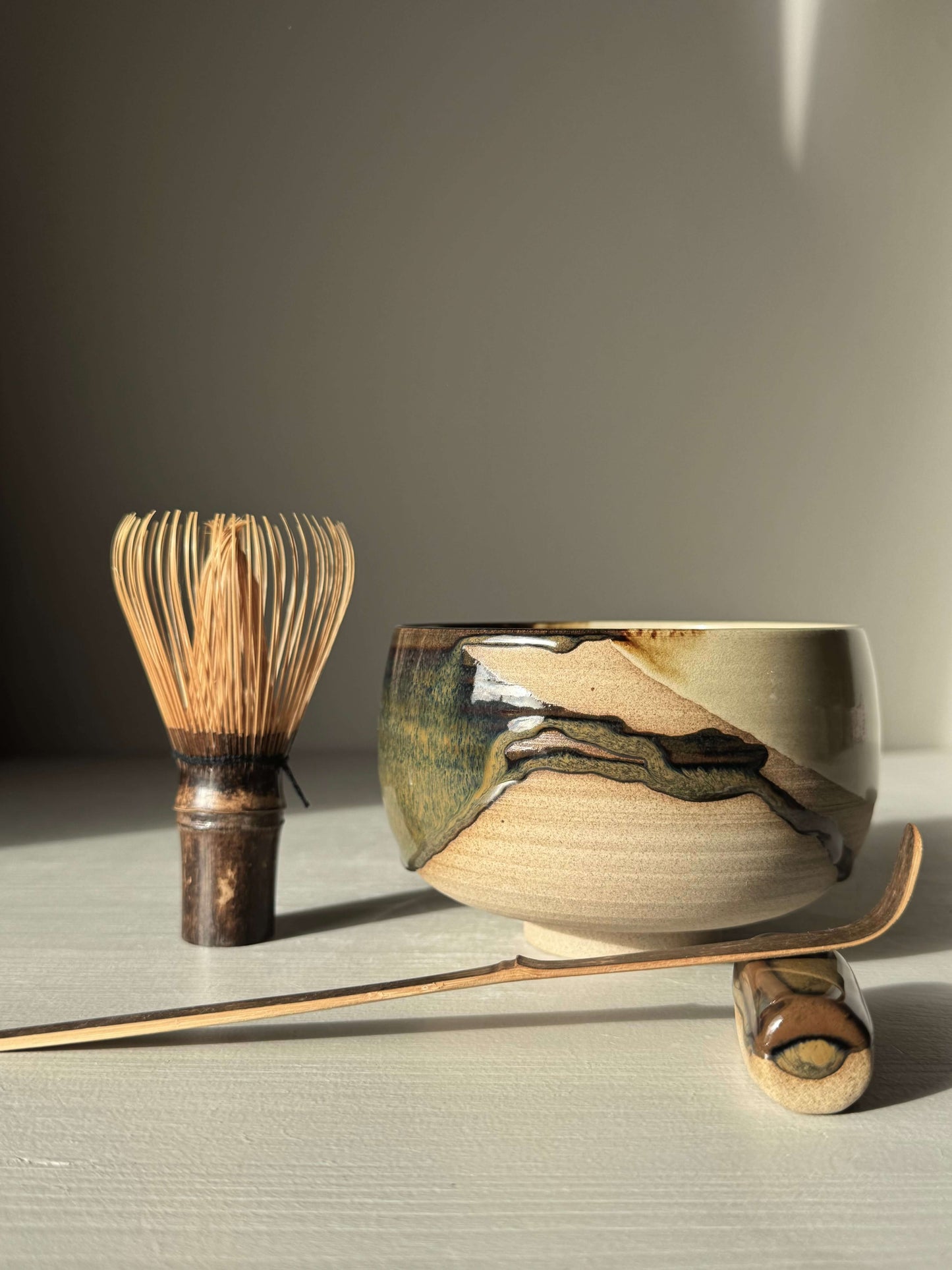 Handmade ceramic Matcha Bowl – Inyo #02 with layered glaze design, alongside matcha whisk and scoop, part of the Inyo Series.