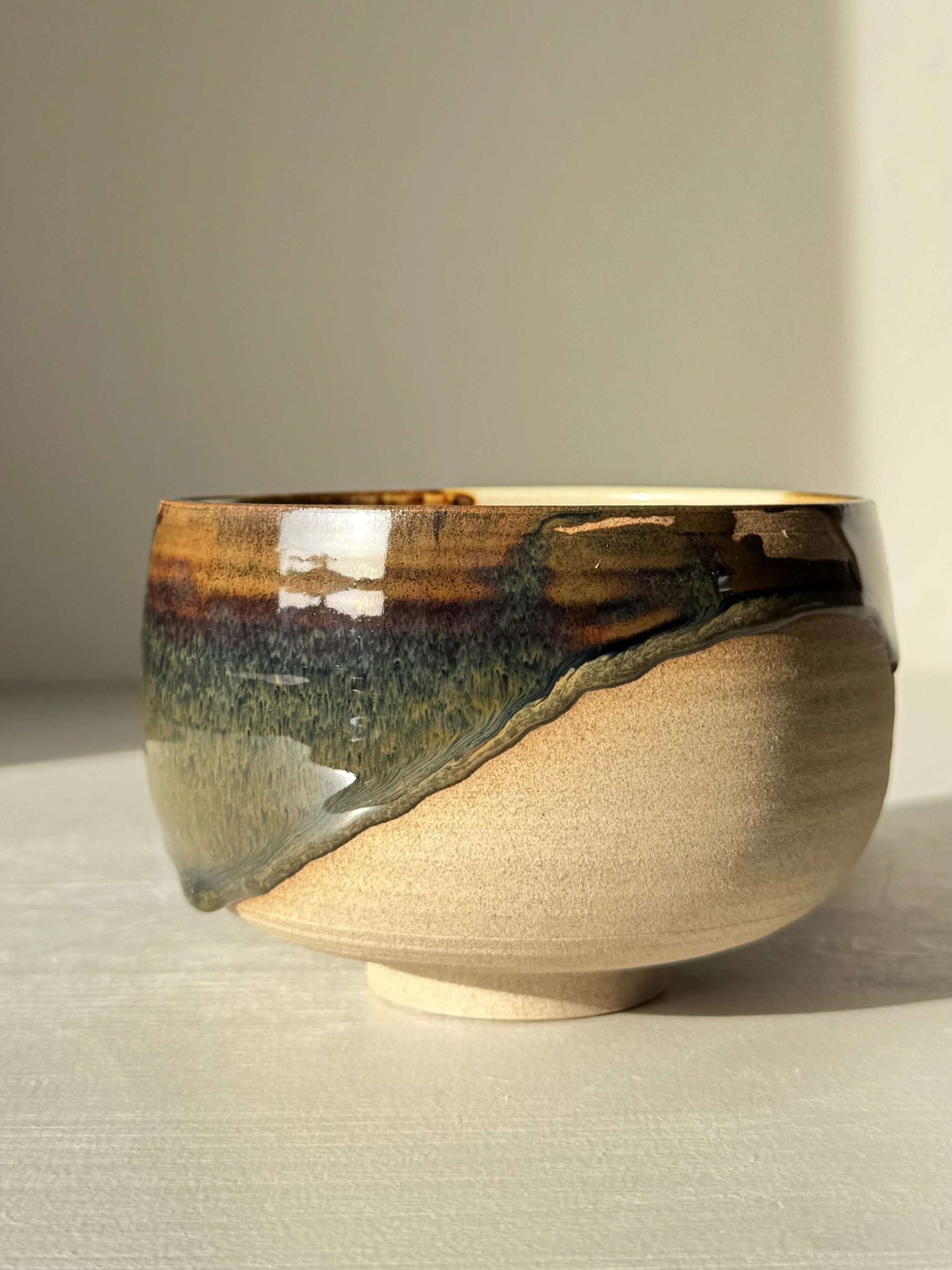 Matcha Bowl – Inyo #06, handmade ceramic bowl with unique glazes, combining dark glossy tenmoku and soft clear on stoneware clay.