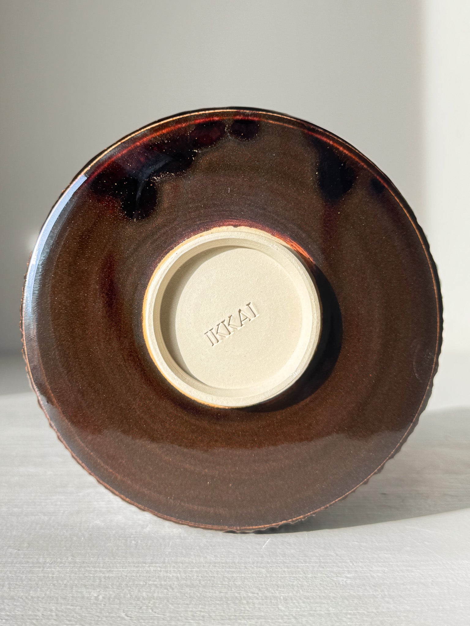 Underside view of Matcha Bowl – Kinsei #02 with glossy brown glaze and embossed base.