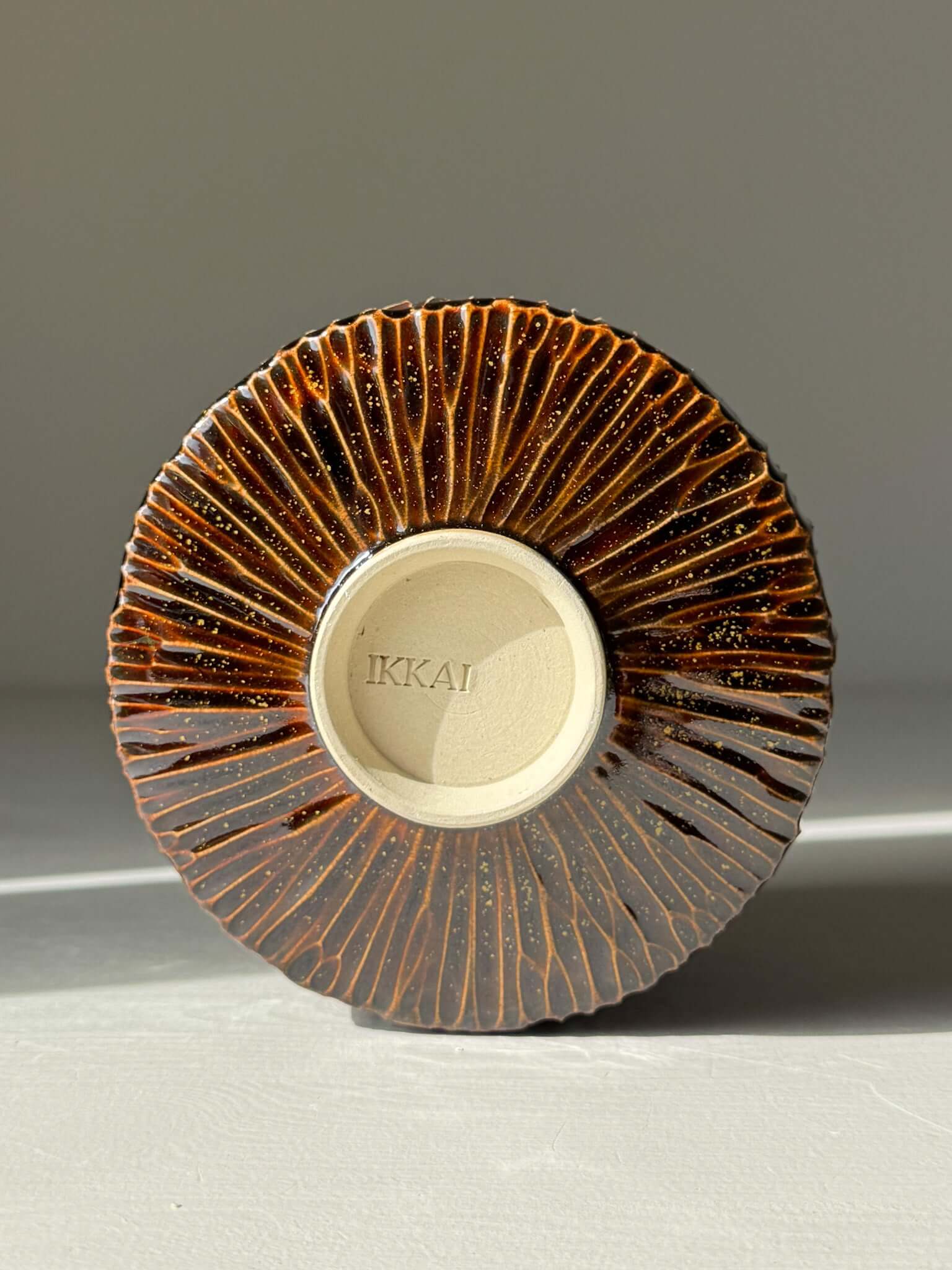 Handmade ceramic Matcha Bowl – Kinsei #02, showing unique glossy brown carved base with dramatic detailing.