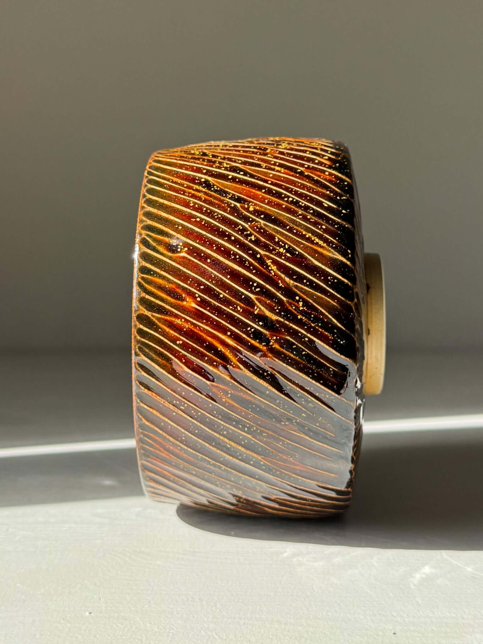 Matcha Bowl – Kinsei #04 handmade ceramic with glossy brown glaze and gold spiral, showcasing unique galaxy-inspired design.