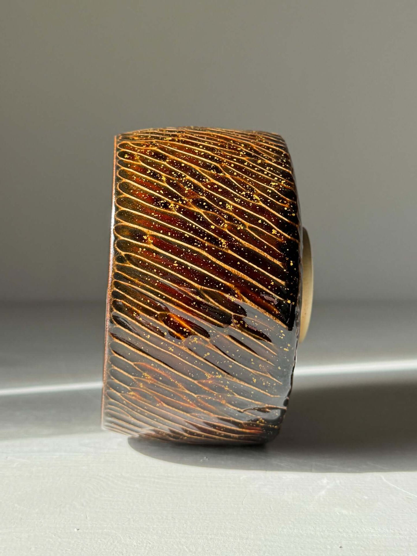 Matcha Bowl – Kinsei #05 handmade ceramic with brown glazed exterior and golden orange spiral interior, 7.5cm x 11cm.