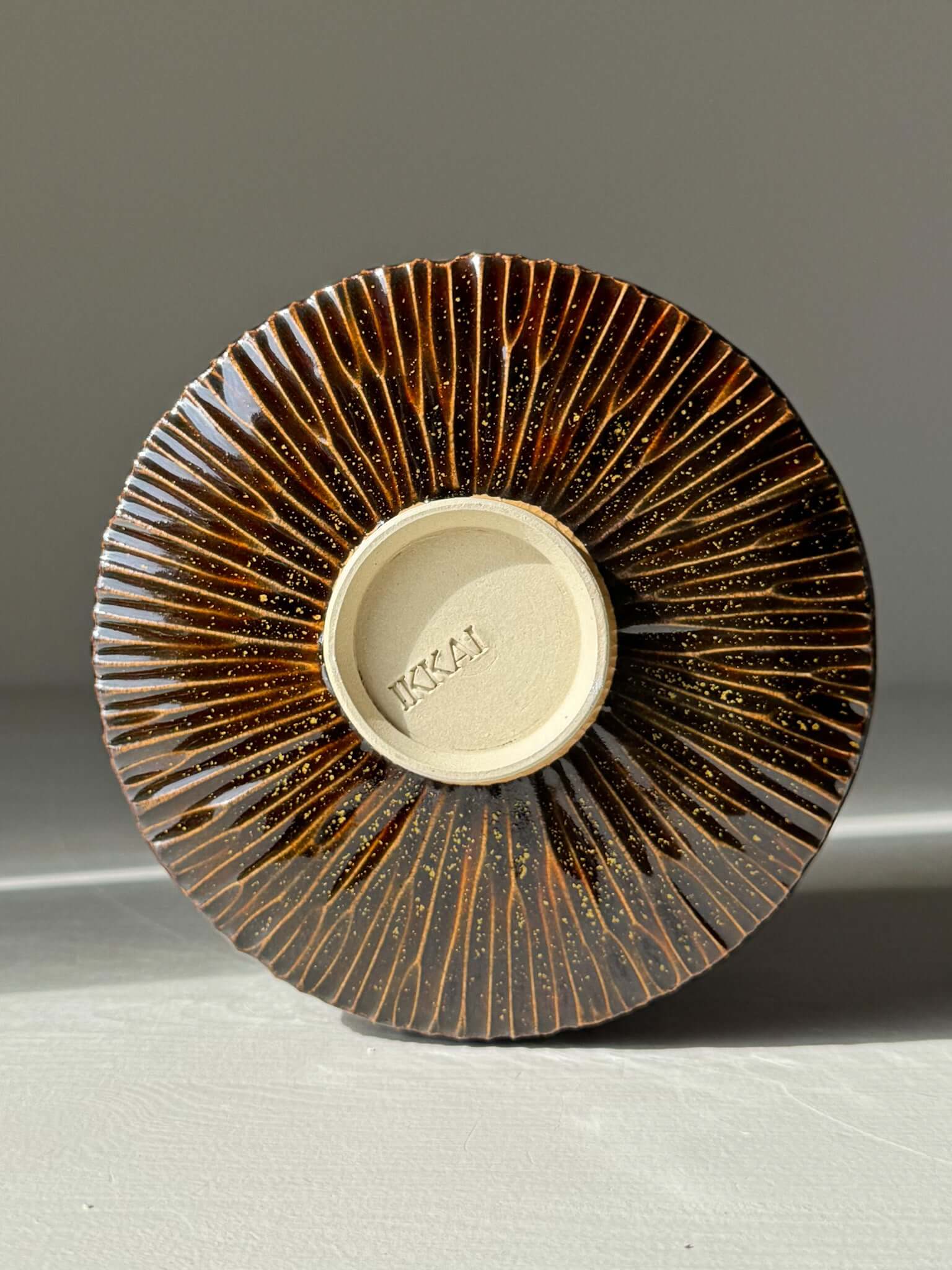 Handmade ceramic Matcha Bowl – Kinsei #03 with glossy brown exterior and spiral design on the bottom.