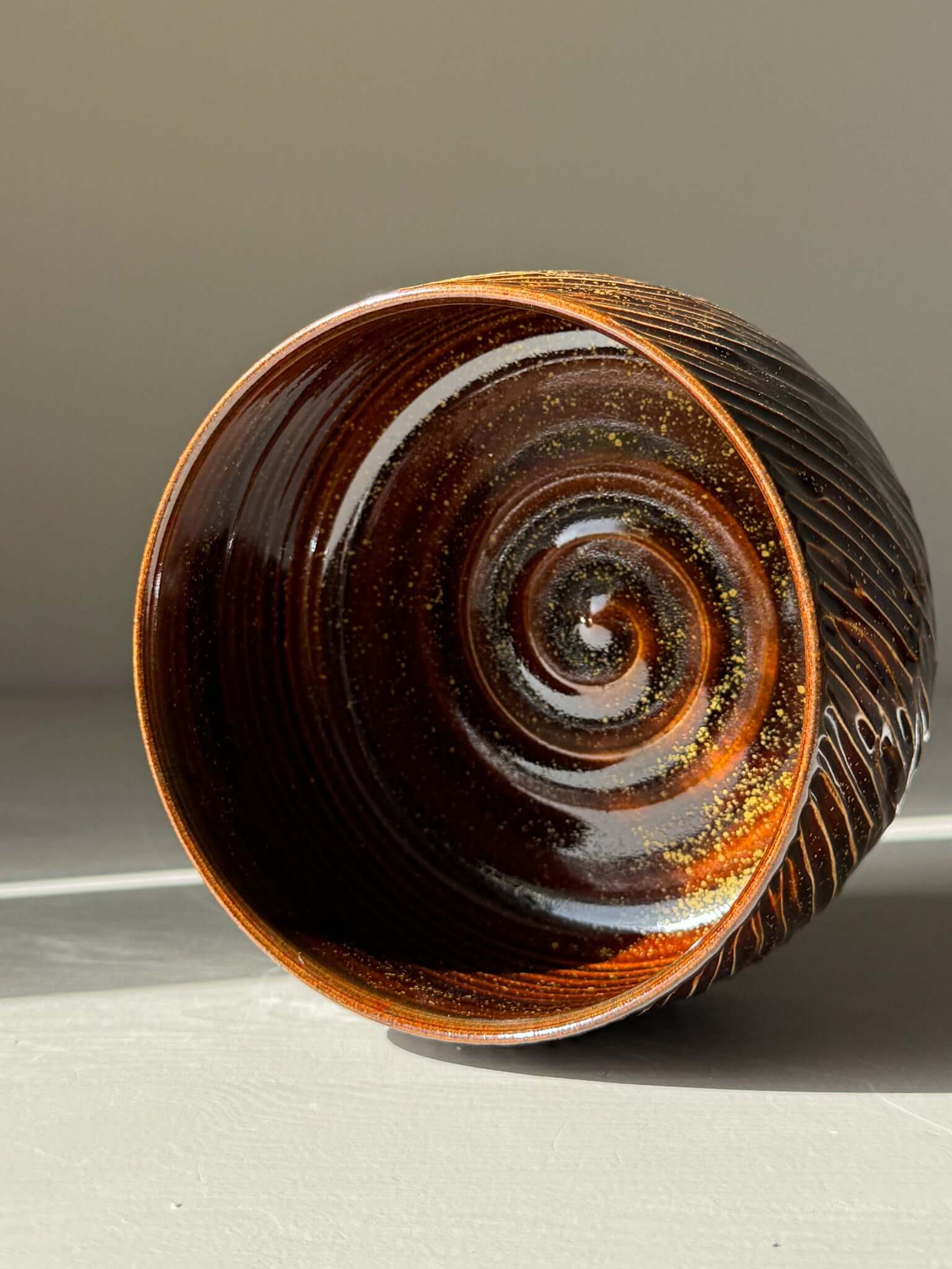 Matcha Bowl – Kinsei #04 handmade ceramic with spiral gold and orange design inside, glossy brown exterior.