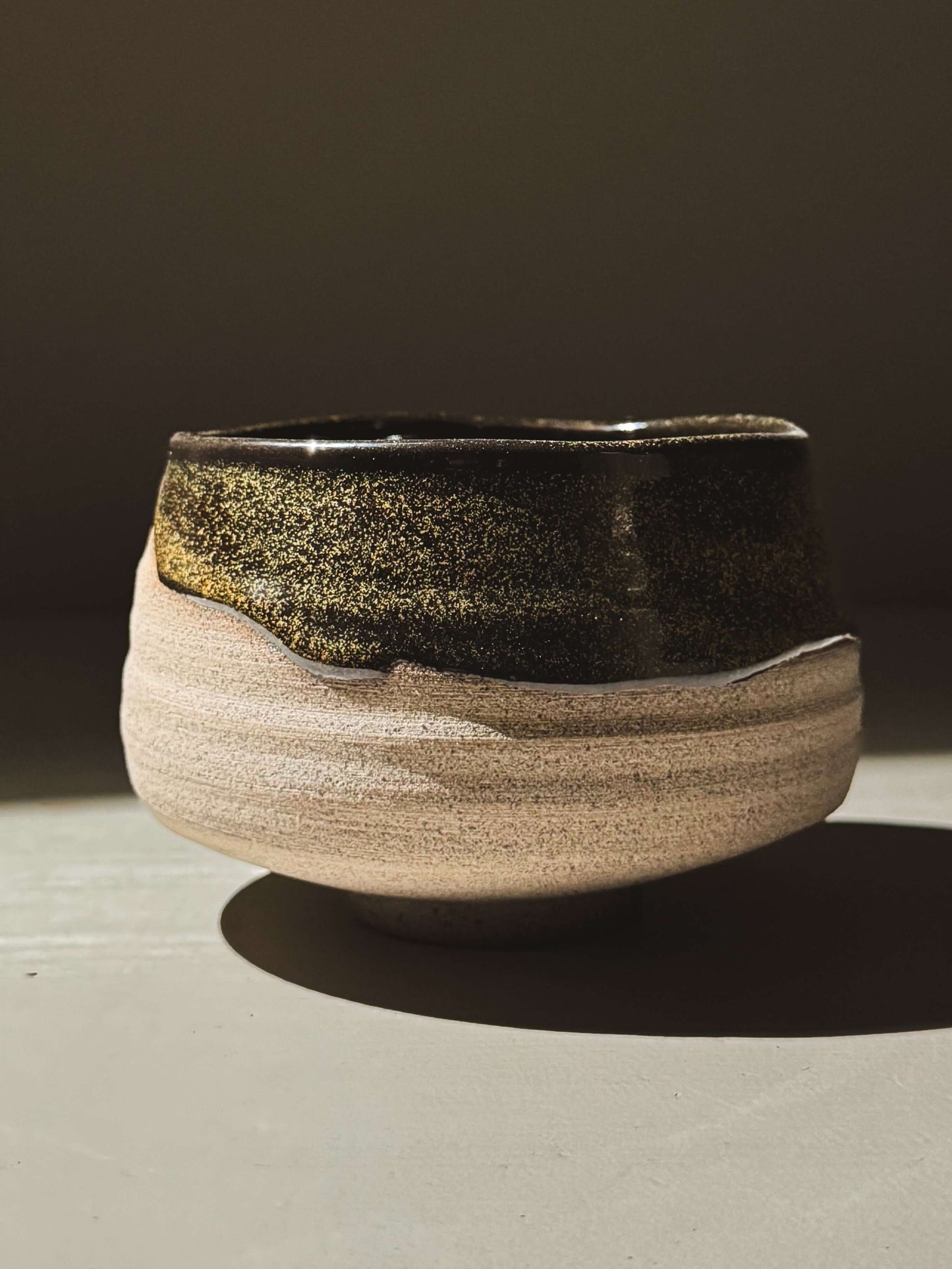 Matcha Bowl – Kuro Ash #03 with glossy black glaze and exposed ash-grey clay, showcasing hand-thrown craftsmanship and unique texture.