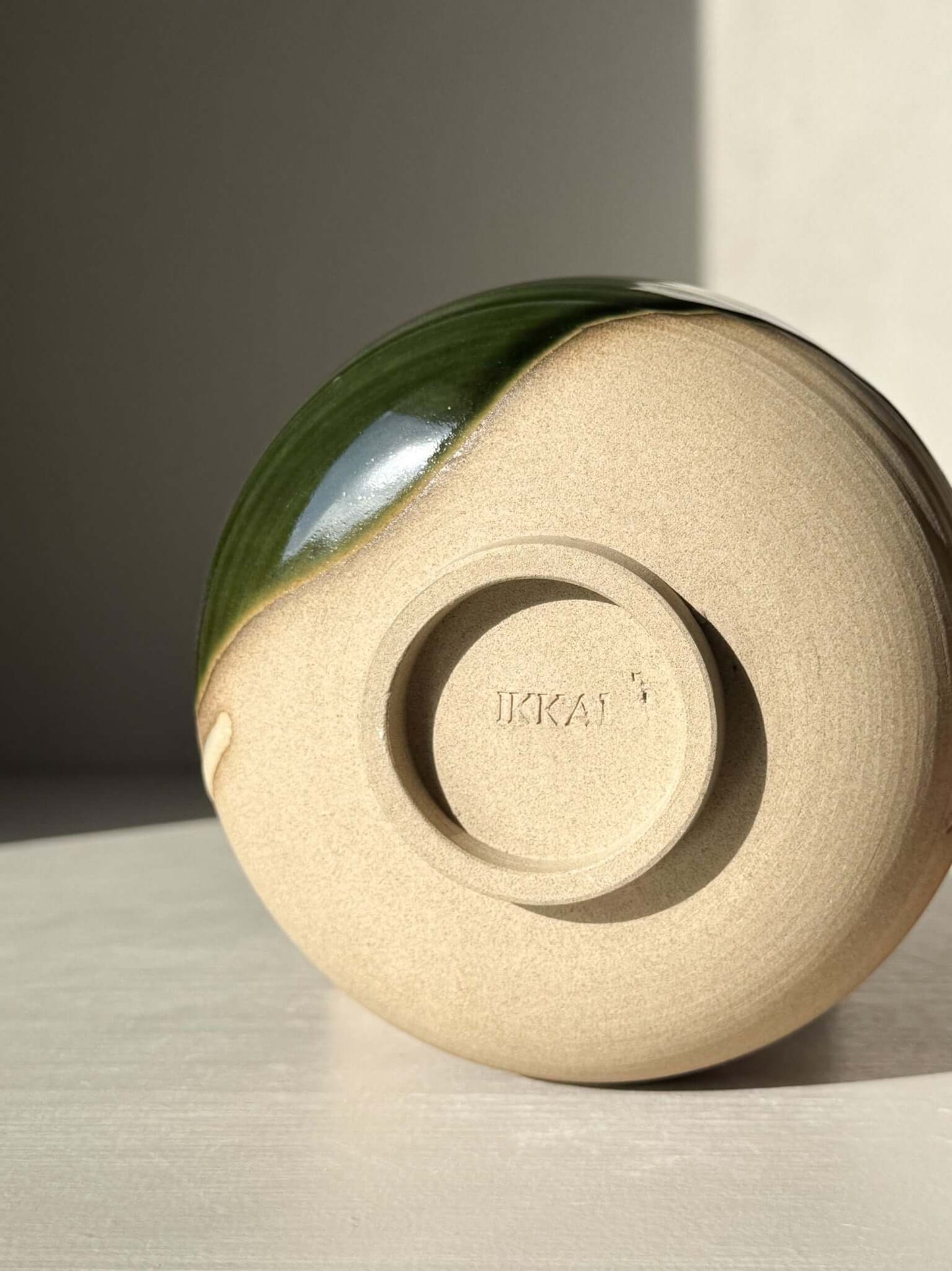 Bottom view of Matcha Bowl – Mori #03 showcasing handmade ceramic design with green and brown glazes.