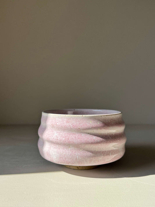 Handmade ceramic Matcha Bowl - Pale Pink with soft glaze and sculpted ridges, under soft light.