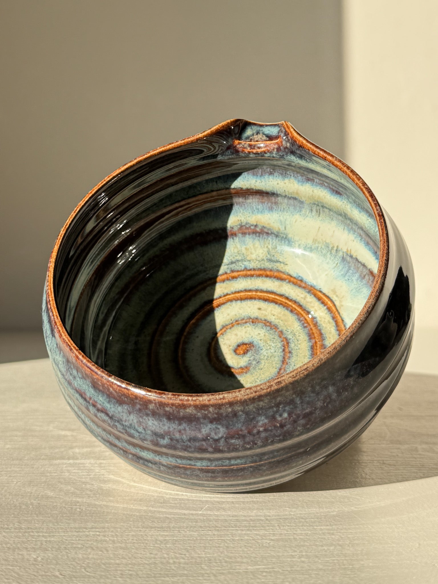 Matcha Bowl Spout - Glossy Blue #01 with swirling earthy tones and a pouring spout, showcasing unique handcrafted design on a raised foot.