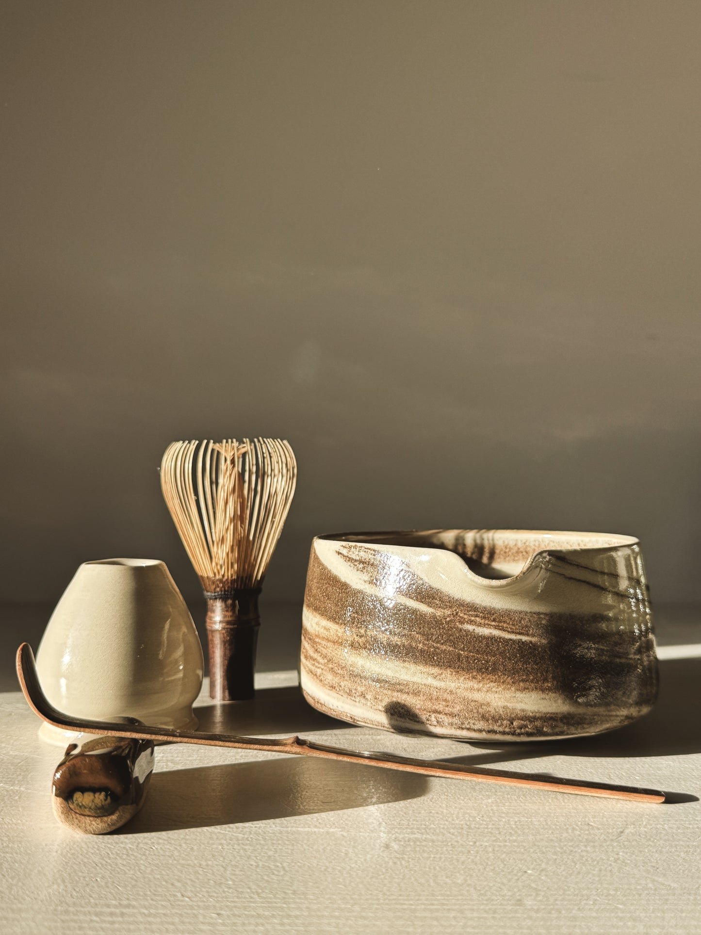 Matcha Bowl Spout - Marbled #01 with black and white swirls, whisk, and tea accessories in natural light setting.