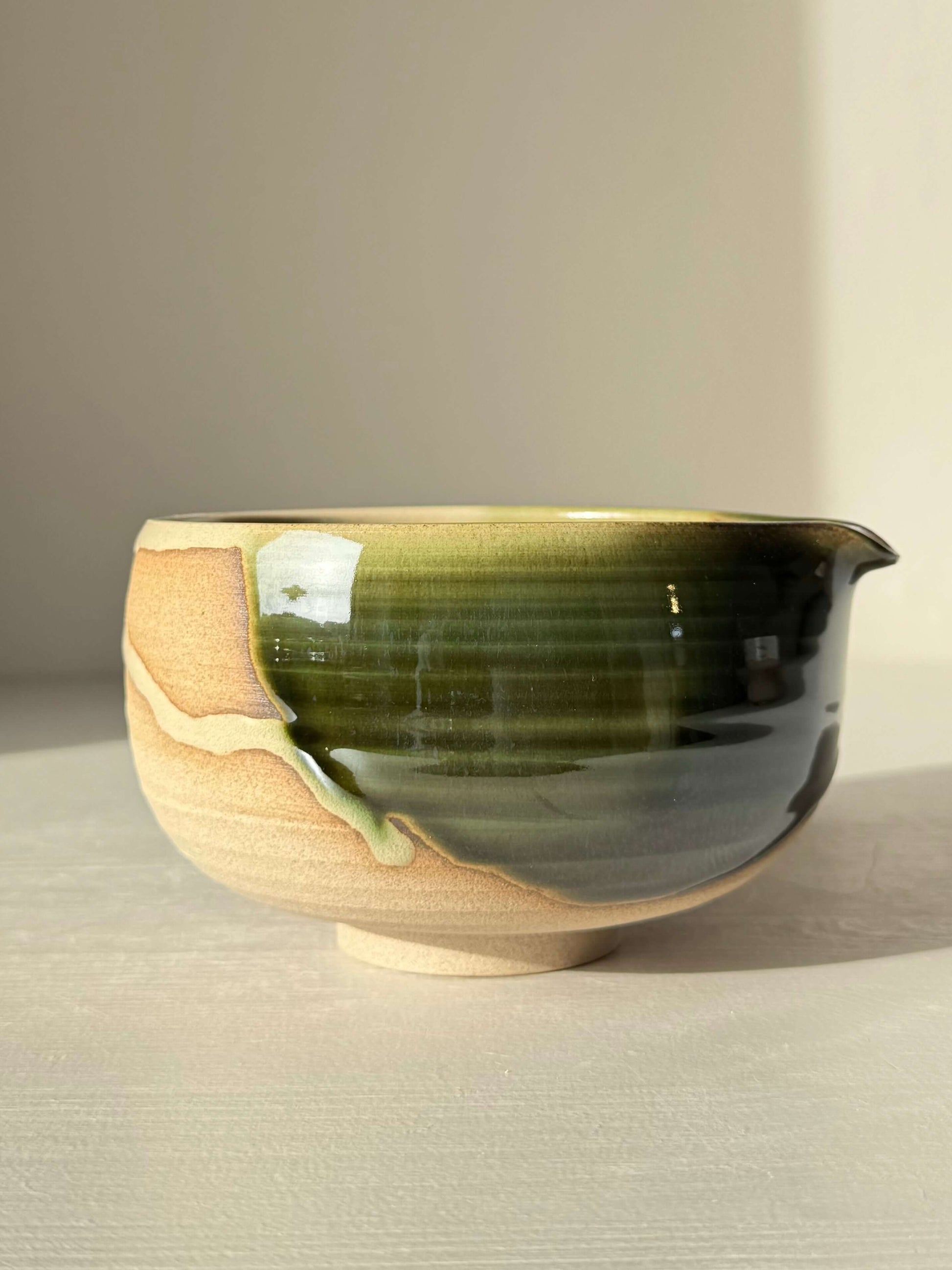 Matcha Bowl with Spout – Mori #06, handmade ceramic with green and brown glaze, showcasing unique organic design