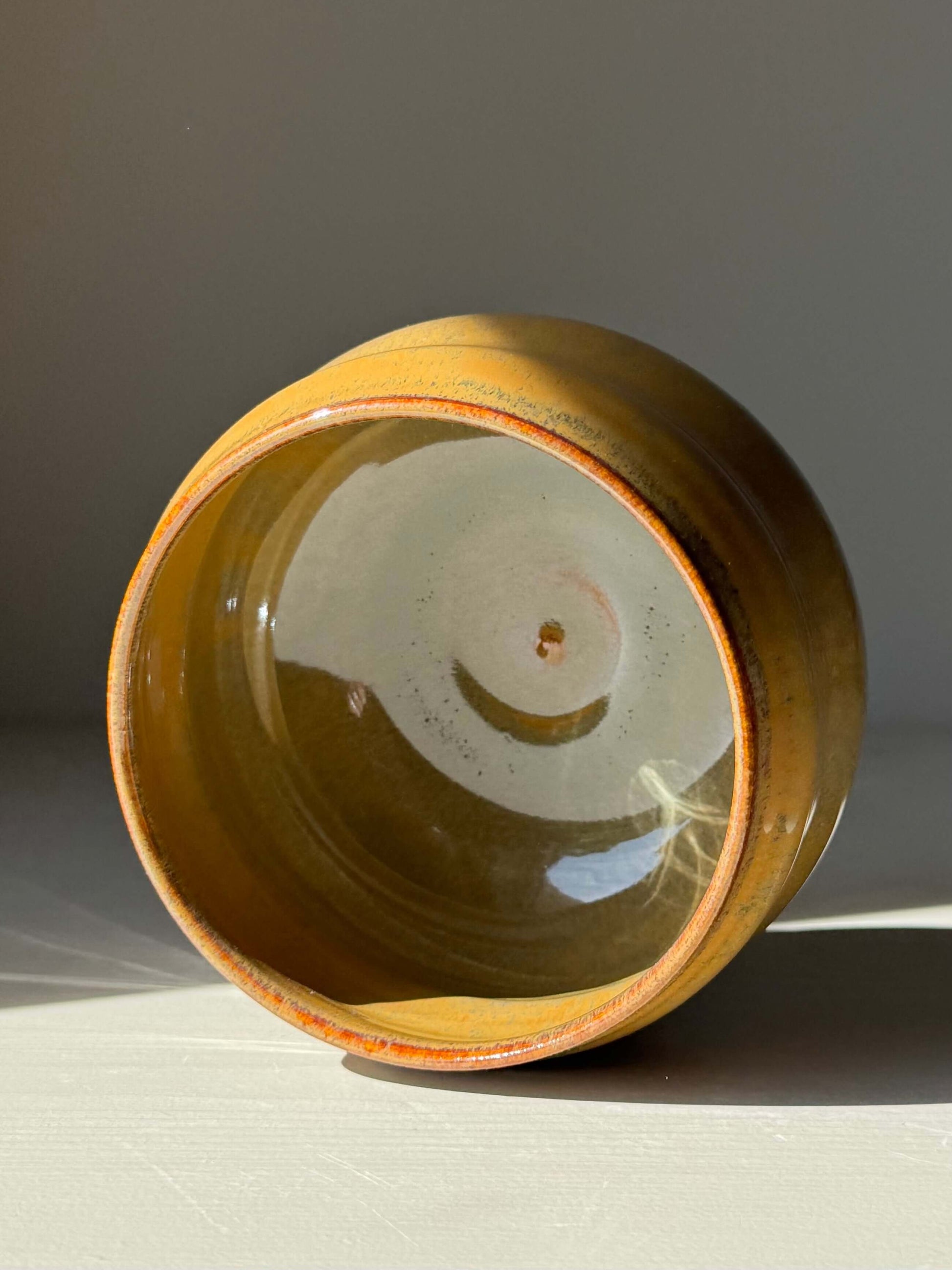 Handmade ceramic Matcha Bowl – Tenmoku Glaze showcasing a rounded form with flowing ridges and a glossy, dark tenmoku finish.