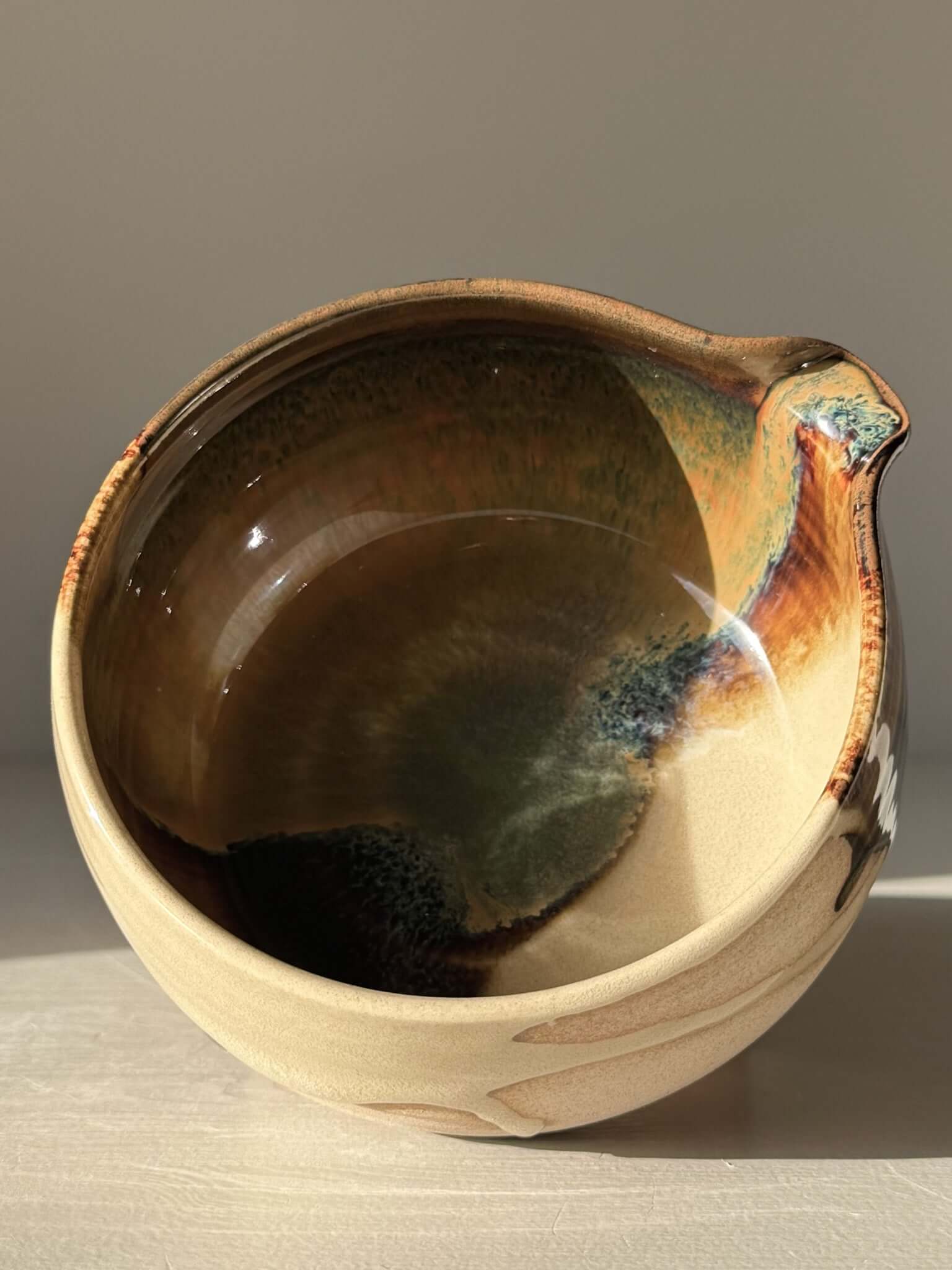 Matcha Bowl with Spout – Inyo #05, handmade ceramic with dark glossy tenmoku and clear glaze on warm stoneware clay.