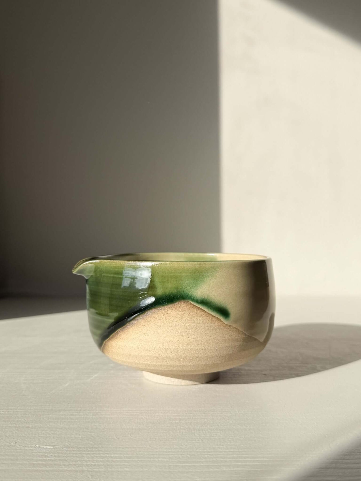 Handmade ceramic Matcha Bowl with Spout – Mori #01 featuring layered green and brown glazes in natural light