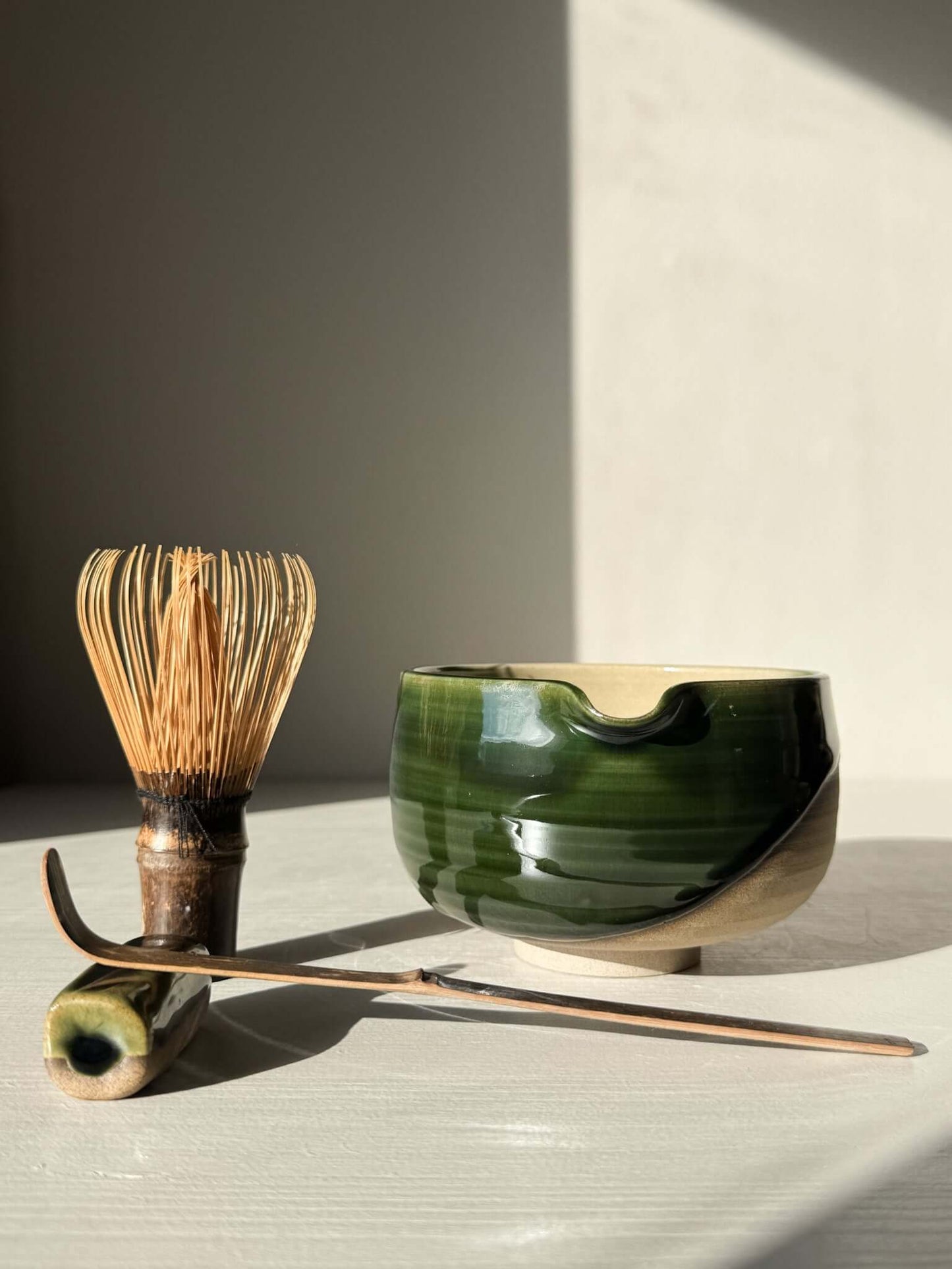 Handmade ceramic Matcha Bowl with Spout – Mori #01 with whisk and spoon, featuring green and brown glazes, part of the Mori Series.