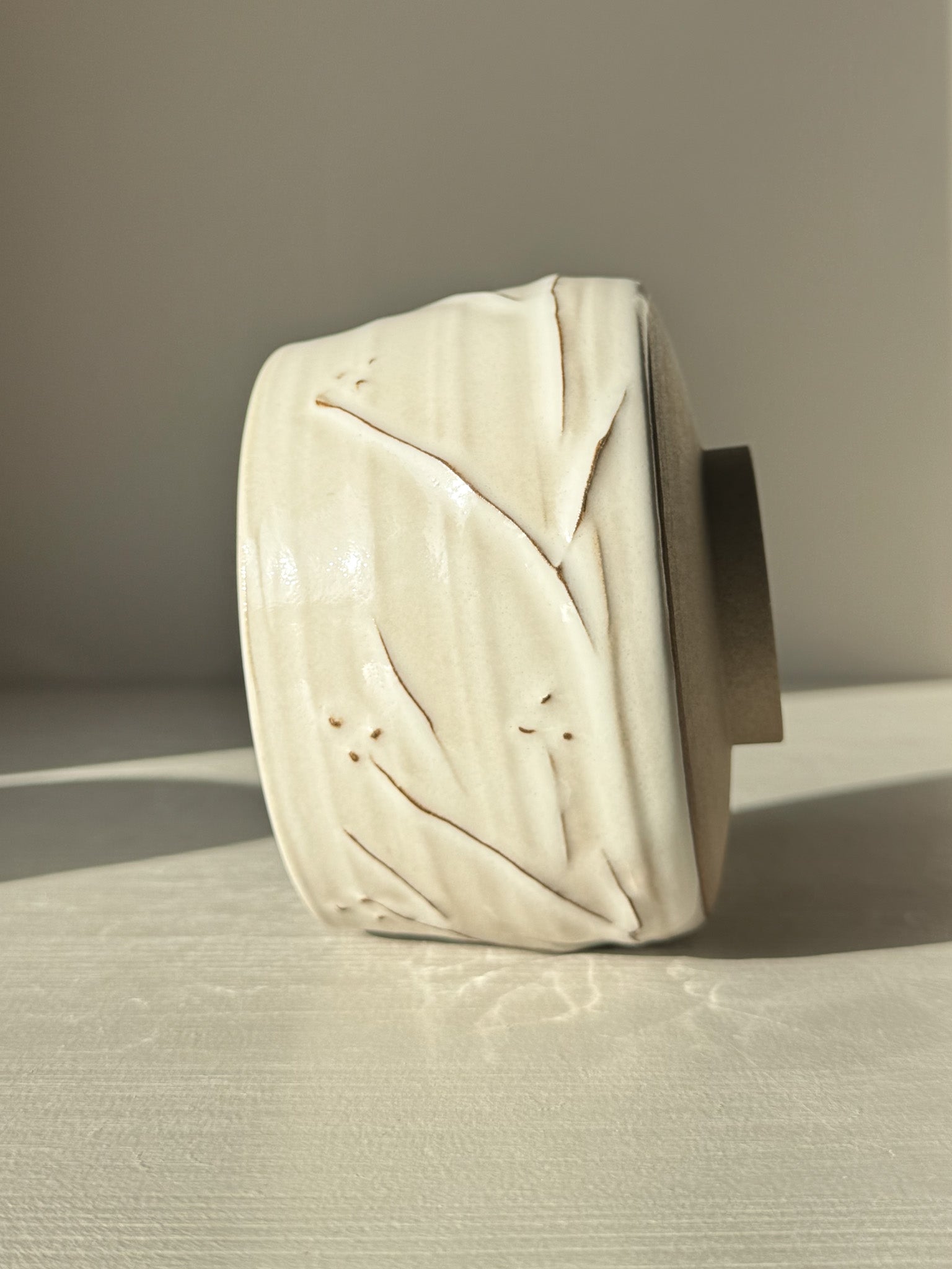 Matcha Bowl – Yuki Branches #02 with ivory glaze and delicate slip lines, showcasing unique craftsmanship against a frosty morning light.