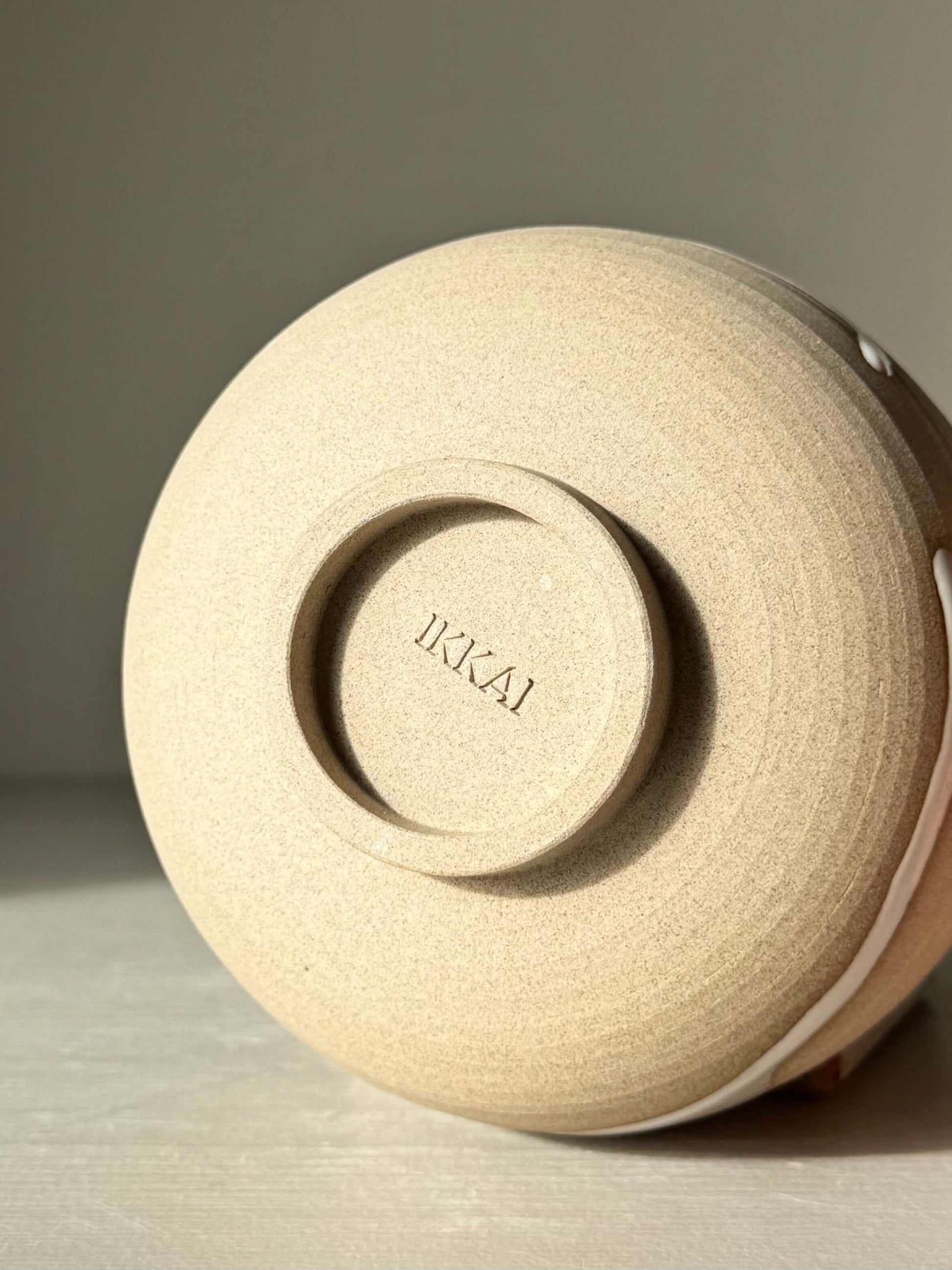 Underside of handmade ceramic Matcha Bowl – Yuki #04 with toffee clay and glossy white glaze details.