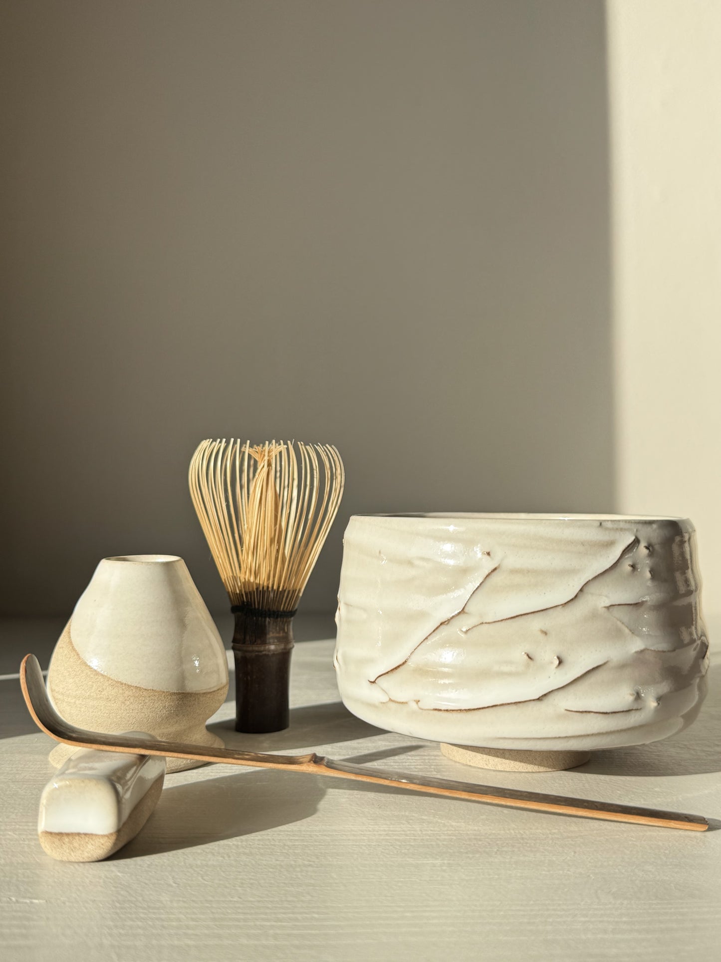 Matcha Bowl – Yuki Branches #01 with whisk, scoop, and water vessel in soft ivory glaze, showcasing delicate slip lines and tactile finish.