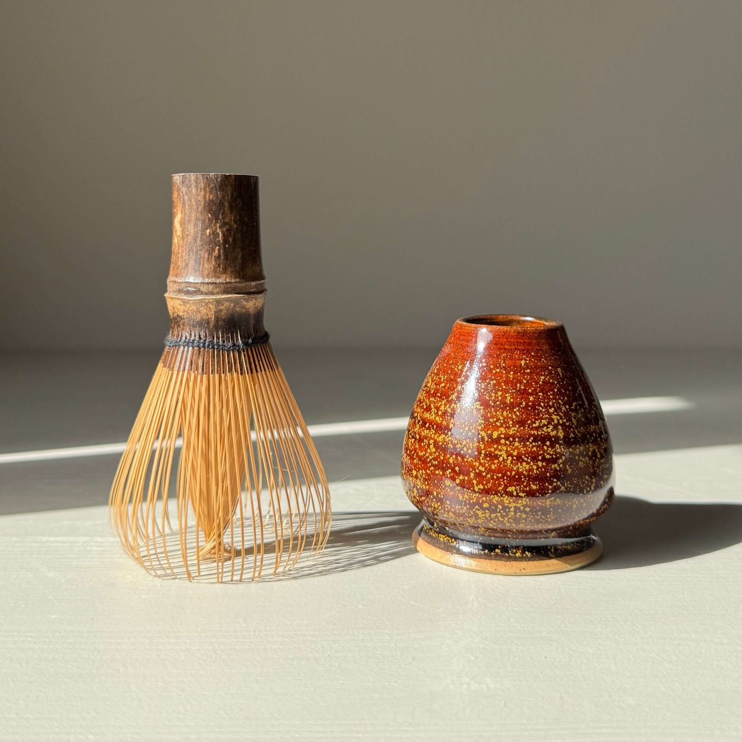 Handmade ceramic Whisk Holder - Kinsei with bamboo matcha whisk, featuring rich amber glaze.
