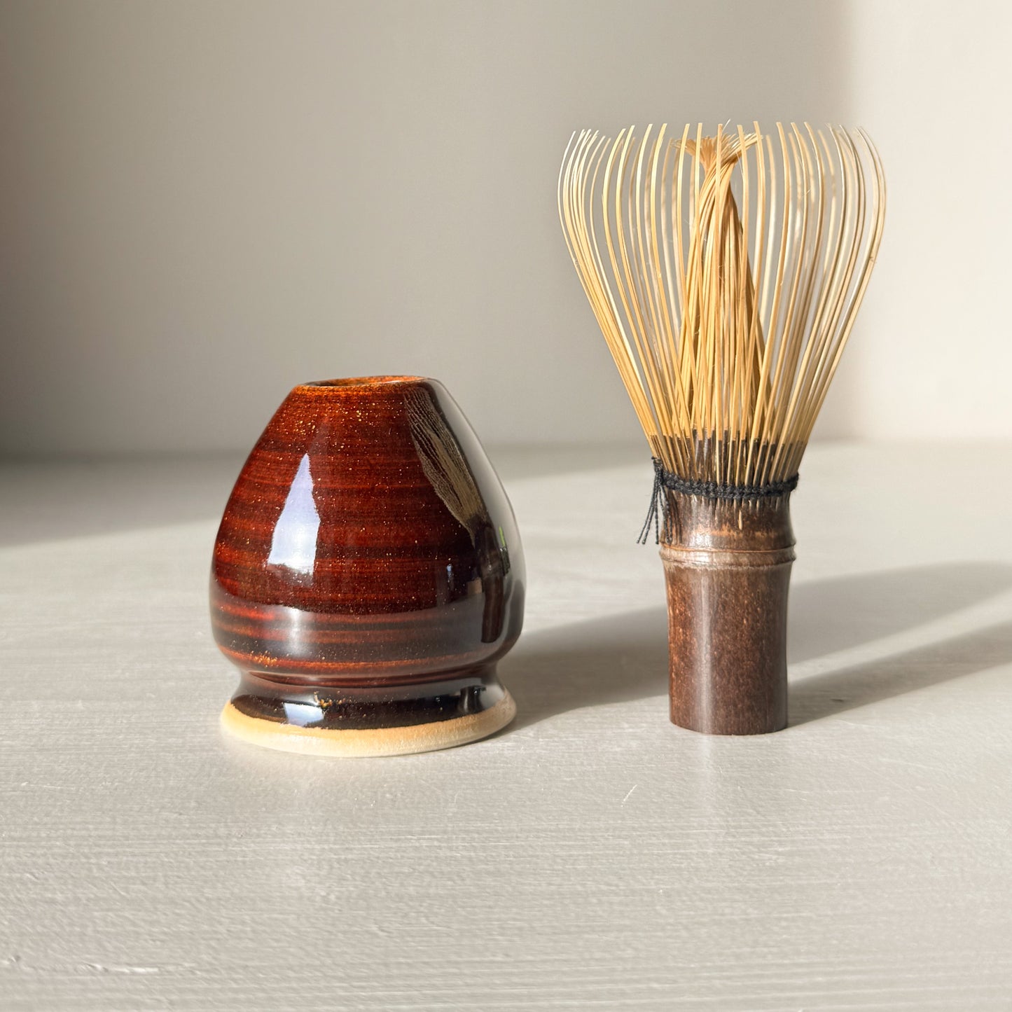 Whisk Holder - Kinsei with bamboo whisk, featuring a rich amber glaze, enhances the aesthetic of your tea setup and maintains whisk longevity.