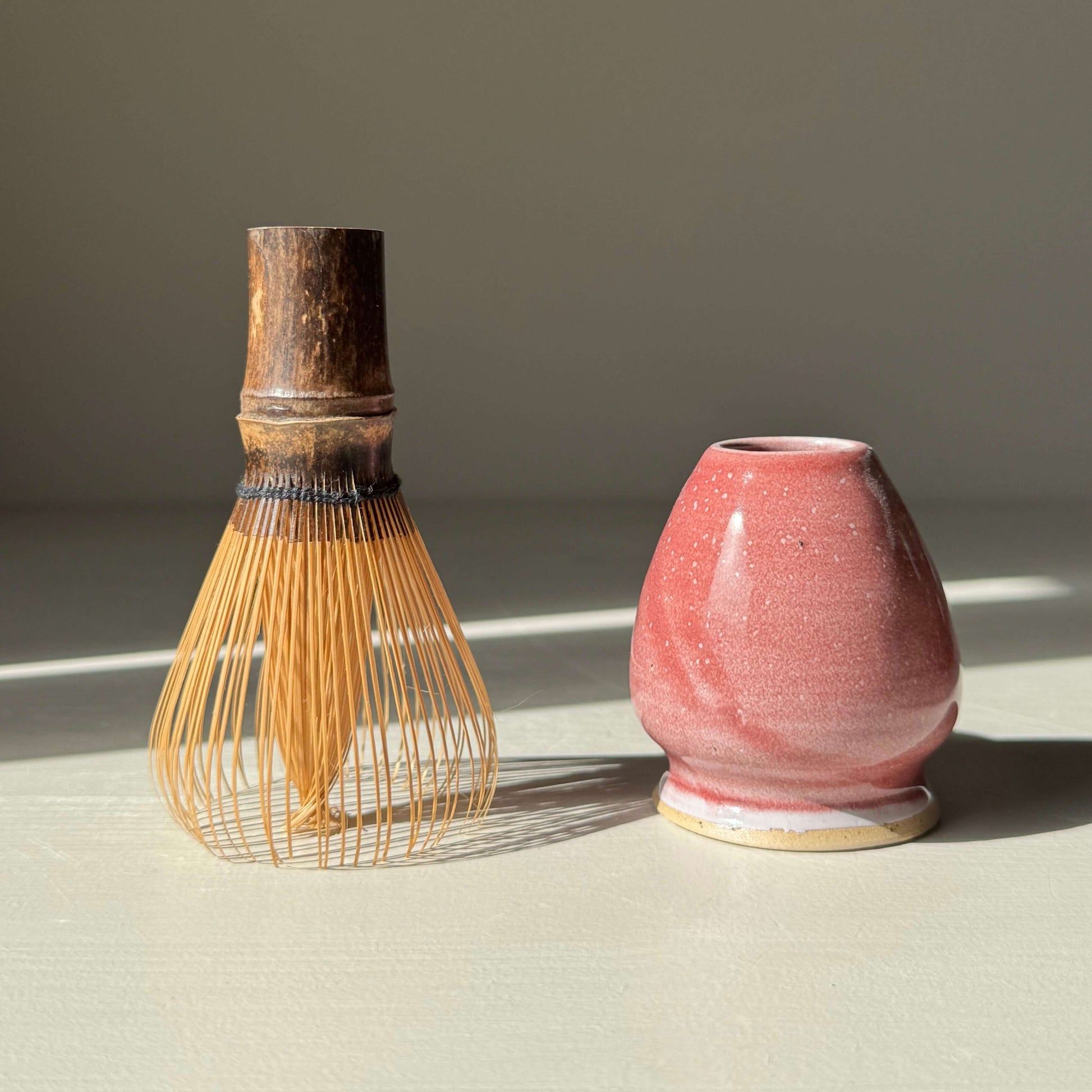 Matcha Whisk Holder - Ume Series with handmade ceramic design next to a bamboo whisk, inspired by Japanese plum blossom.