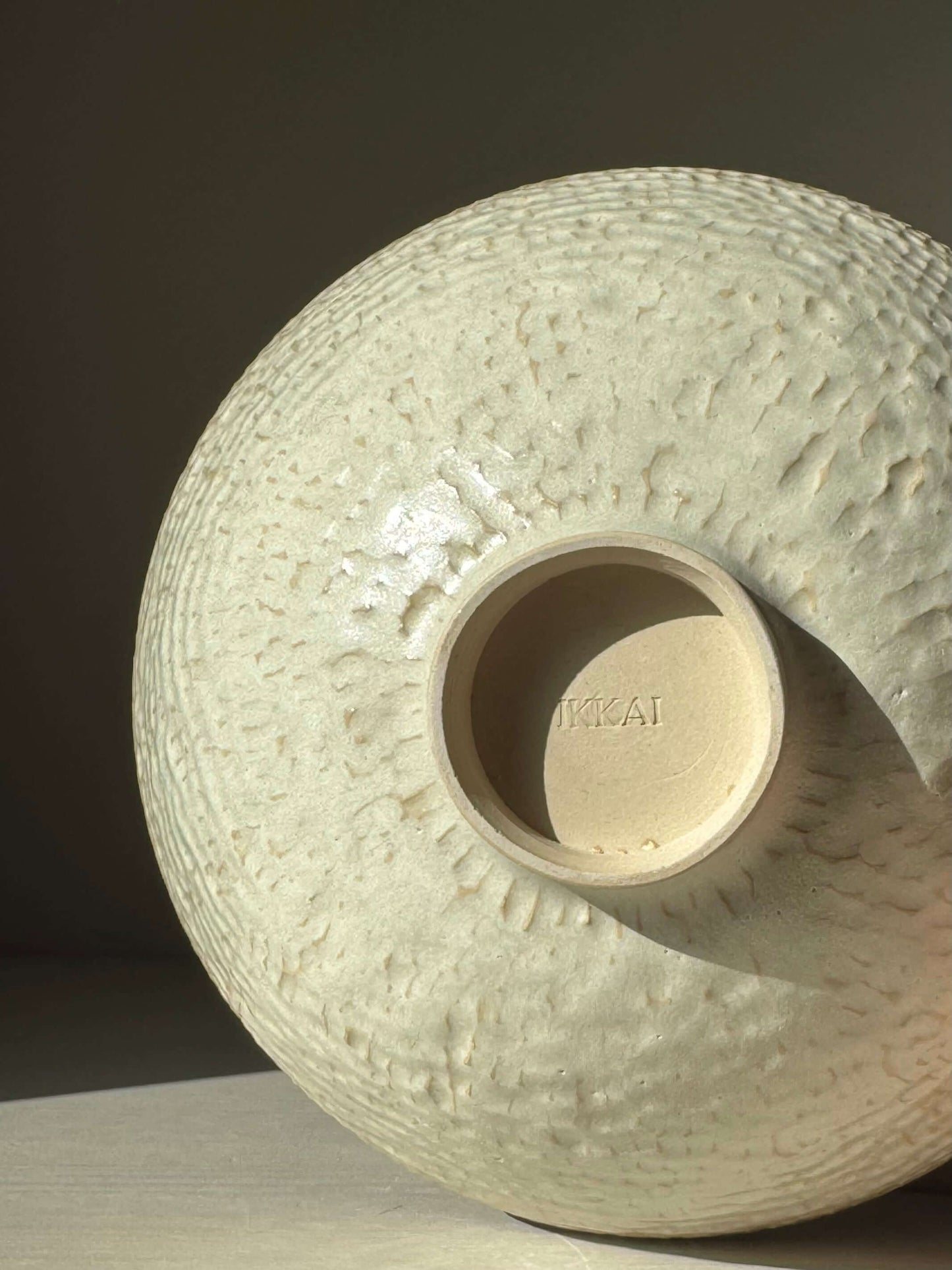 Handmade ceramic Medium Bowl – Moonstone with carved texture, showcasing satin finish and warm rim, reflecting natural light.