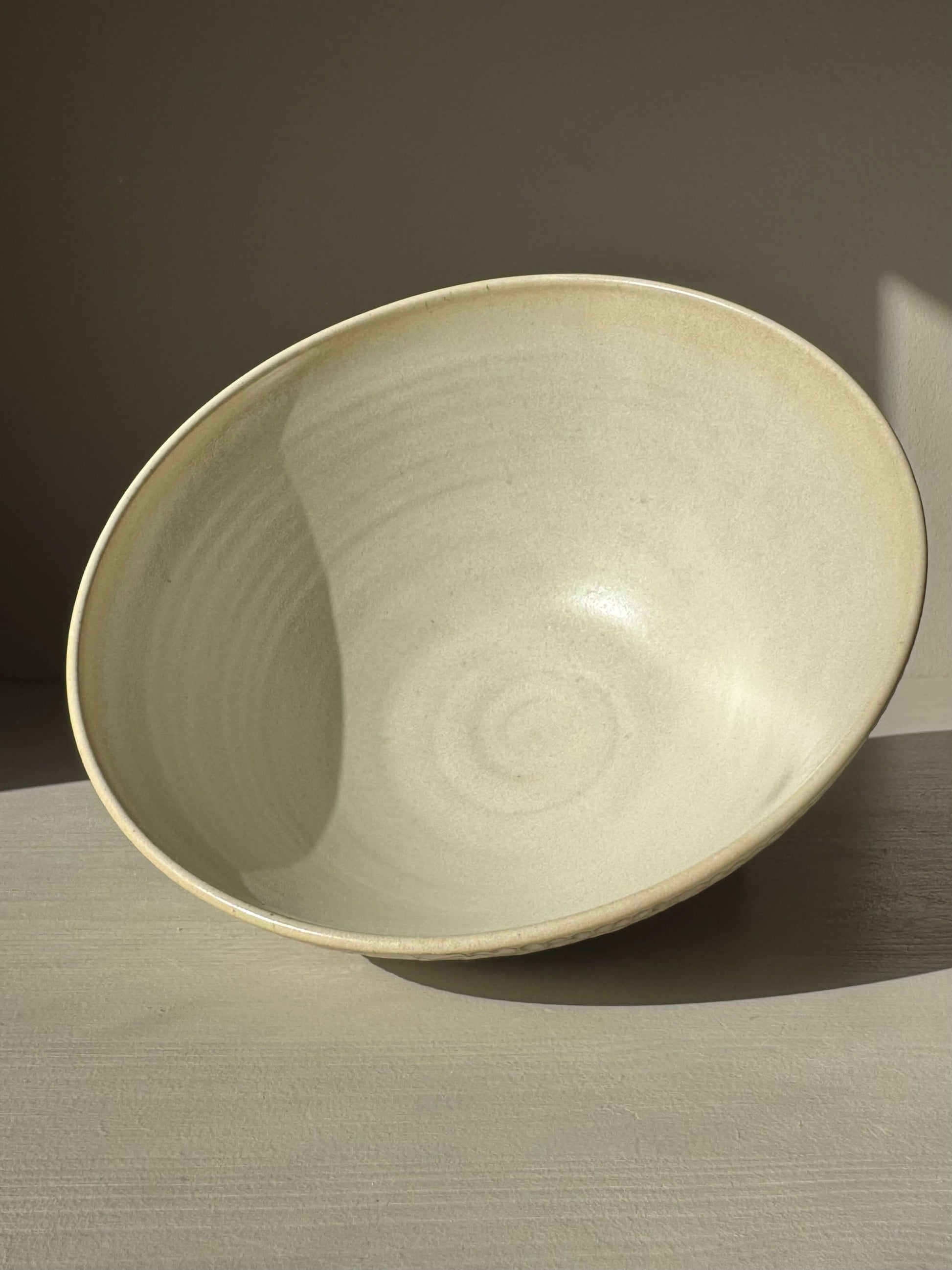 Medium Bowl – Moonstone handmade ceramic with creamy satin finish and hand-carved texture, elegantly placed in soft light.