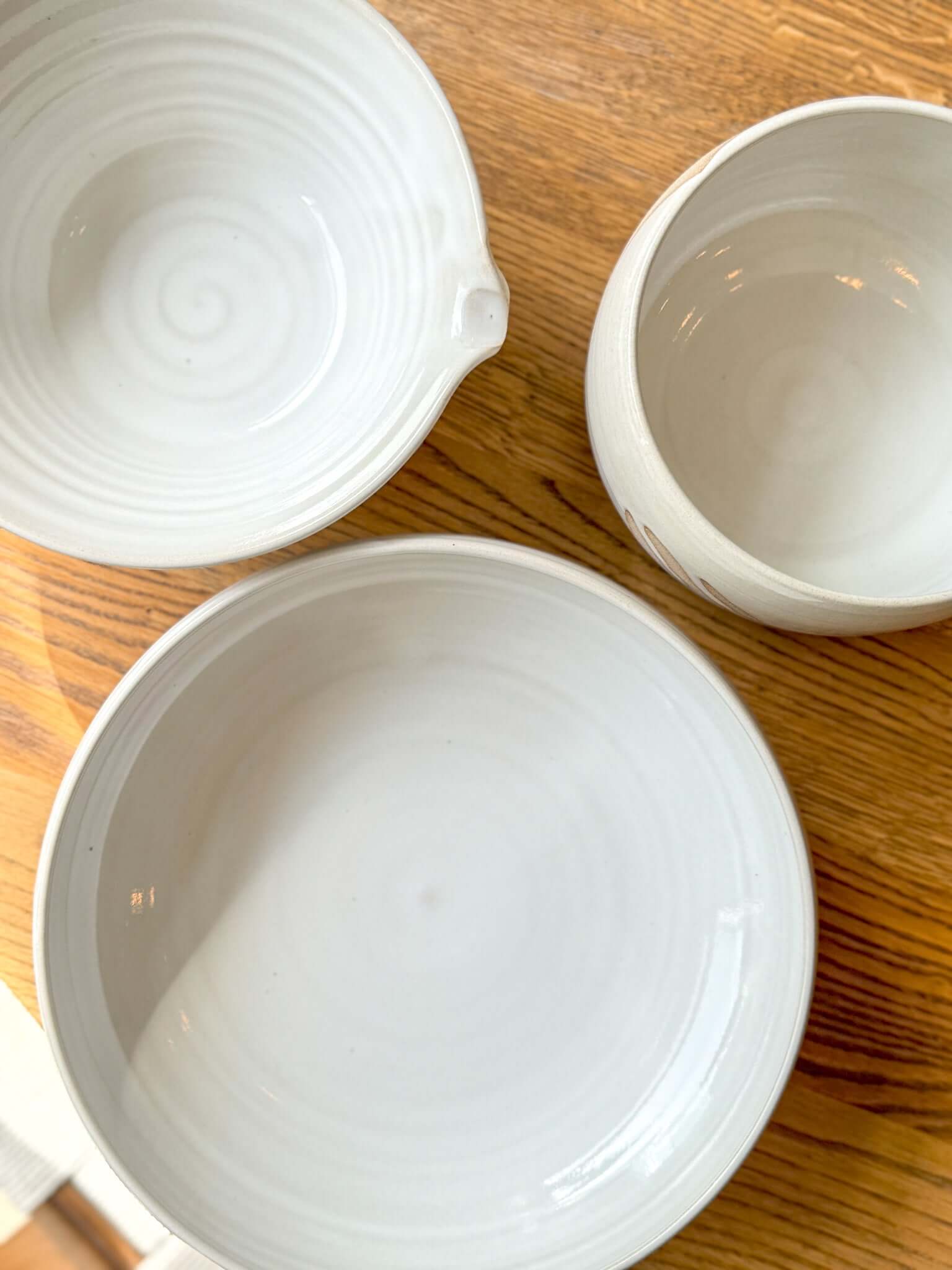 Top view of handmade ceramic Medium Bowl - Yuki #01, with glossy white glaze on rustic wooden surface.