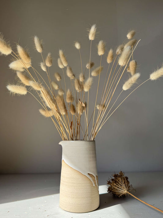 Medium Vase / Jug – Yuki Series: handmade ceramic with glossy white glaze, unglazed toffee base, showcasing tall natural grasses indoors.