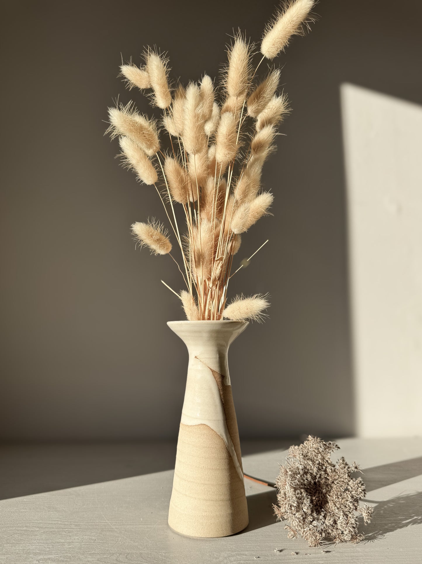 Stylish dried floral arrangement in a flared stoneware Medium Vase – Yuki #01, featuring a unique glossy white and natural finish.