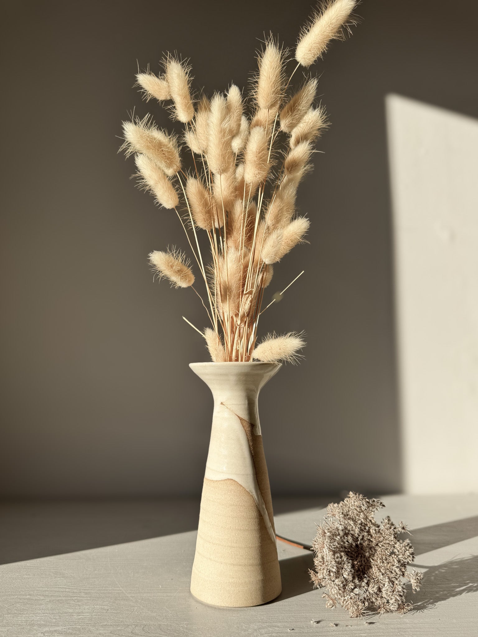 Stylish dried floral arrangement in a flared stoneware Medium Vase – Yuki #01, featuring a unique glossy white and natural finish.