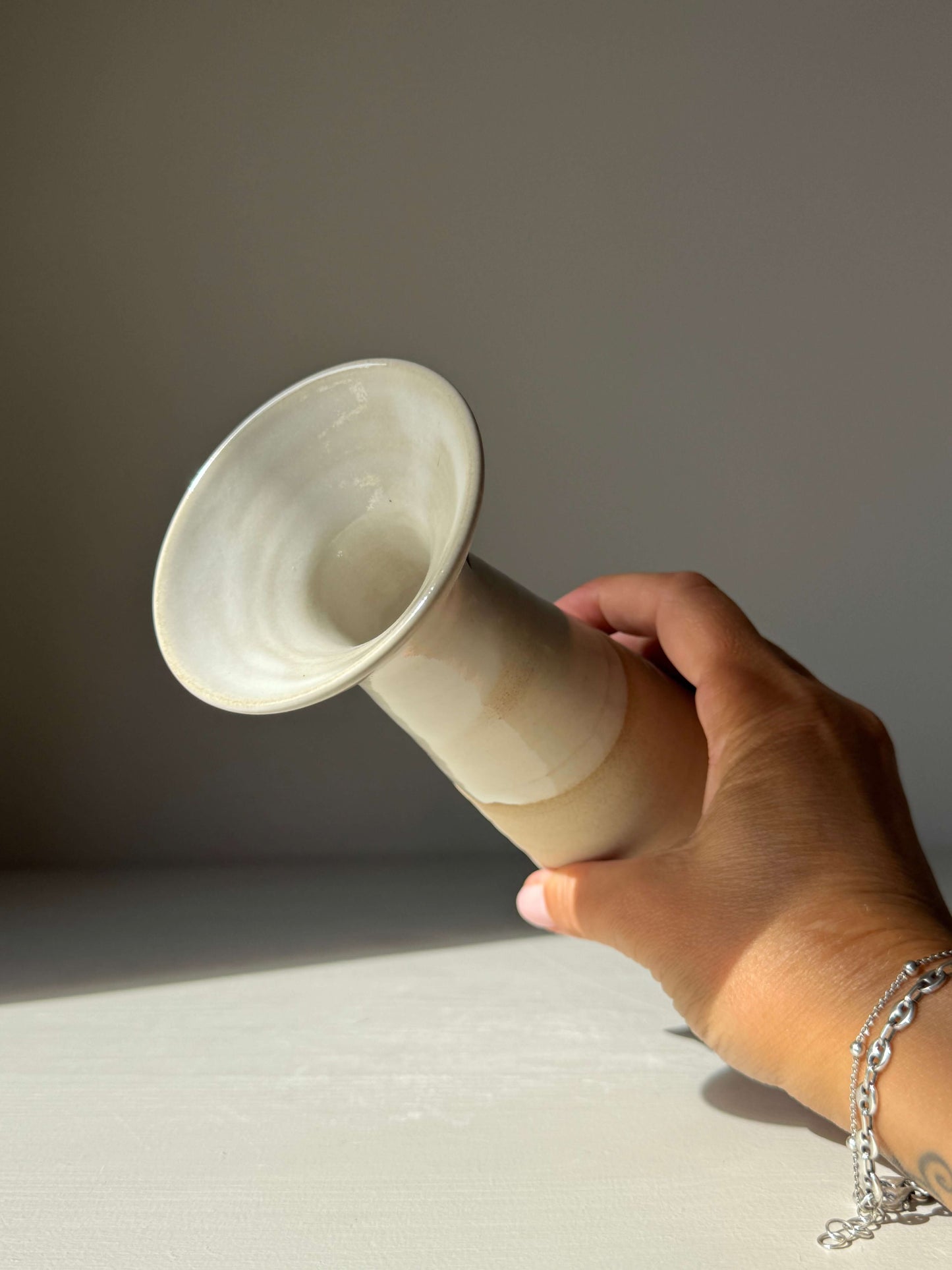 Medium Vase – Yuki #02, handmade ceramic with glossy white glaze held by hand. Tall shape, elegant design capturing calm Yuki Series spirit.