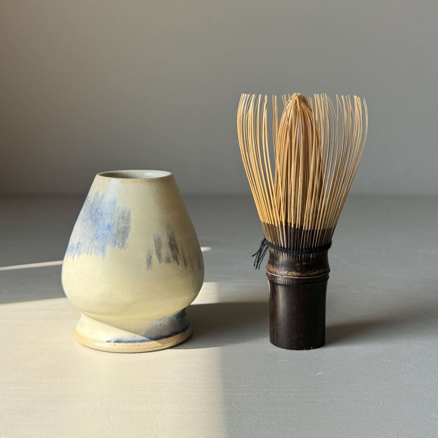 Handmade ceramic Whisk Holder - Blue & Moonstone with bamboo whisk, designed for optimal drying and aesthetic appeal in tea setup.